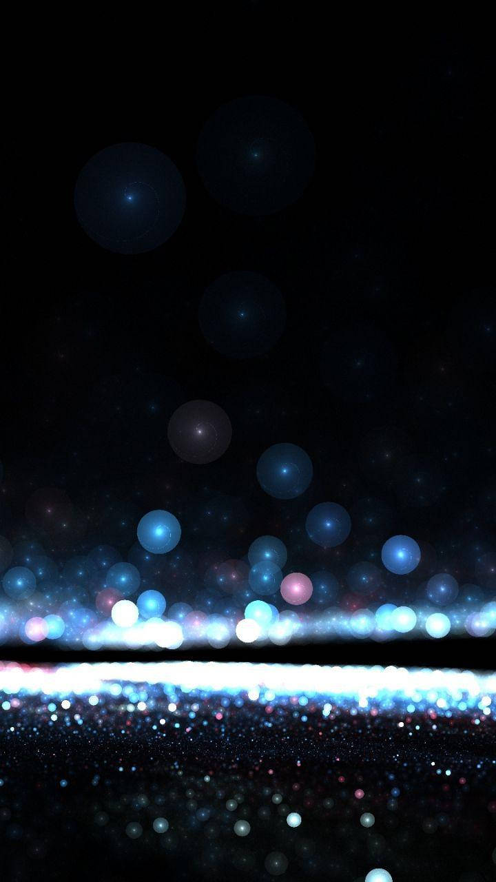 Teléfono oscuro con orbes azules brillantes Fondos de pantalla