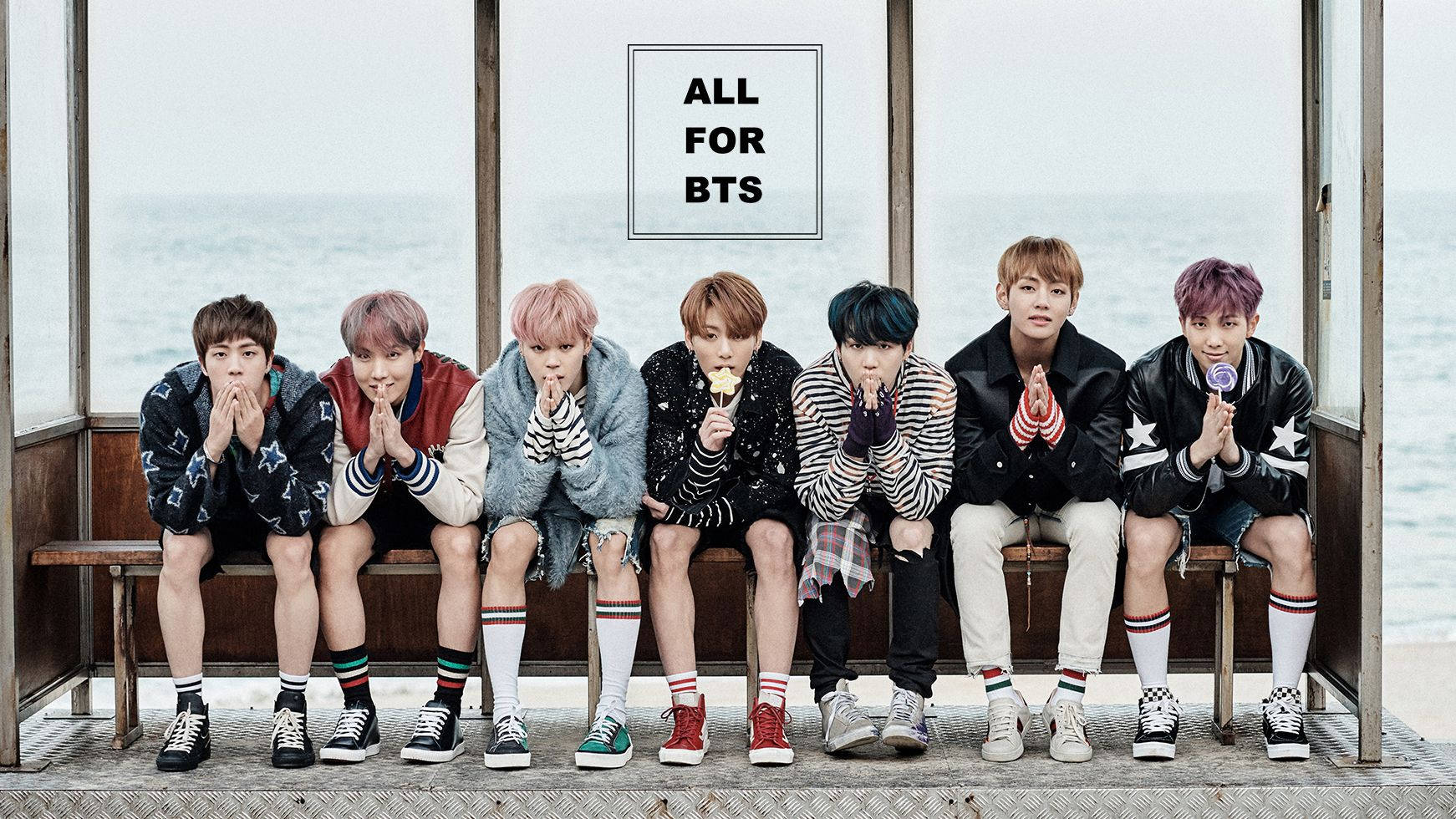 Miembro de la banda BTS sentado en un sofá mirándote.