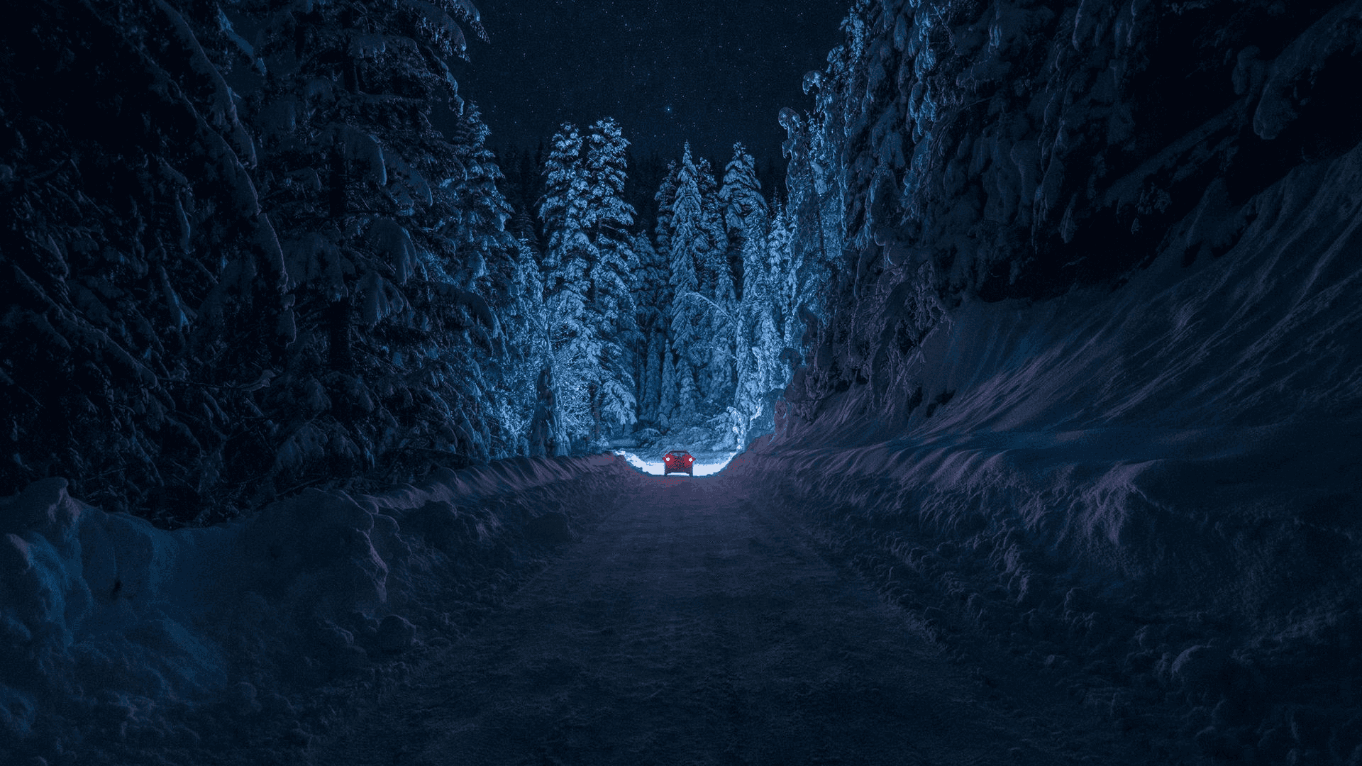 un camino nevado con una luz azul en medio Fondos de pantalla