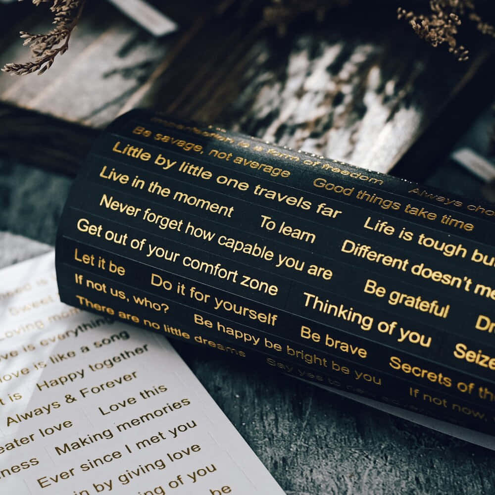 un cuaderno negro y dorado con palabras escritas Fondos de pantalla