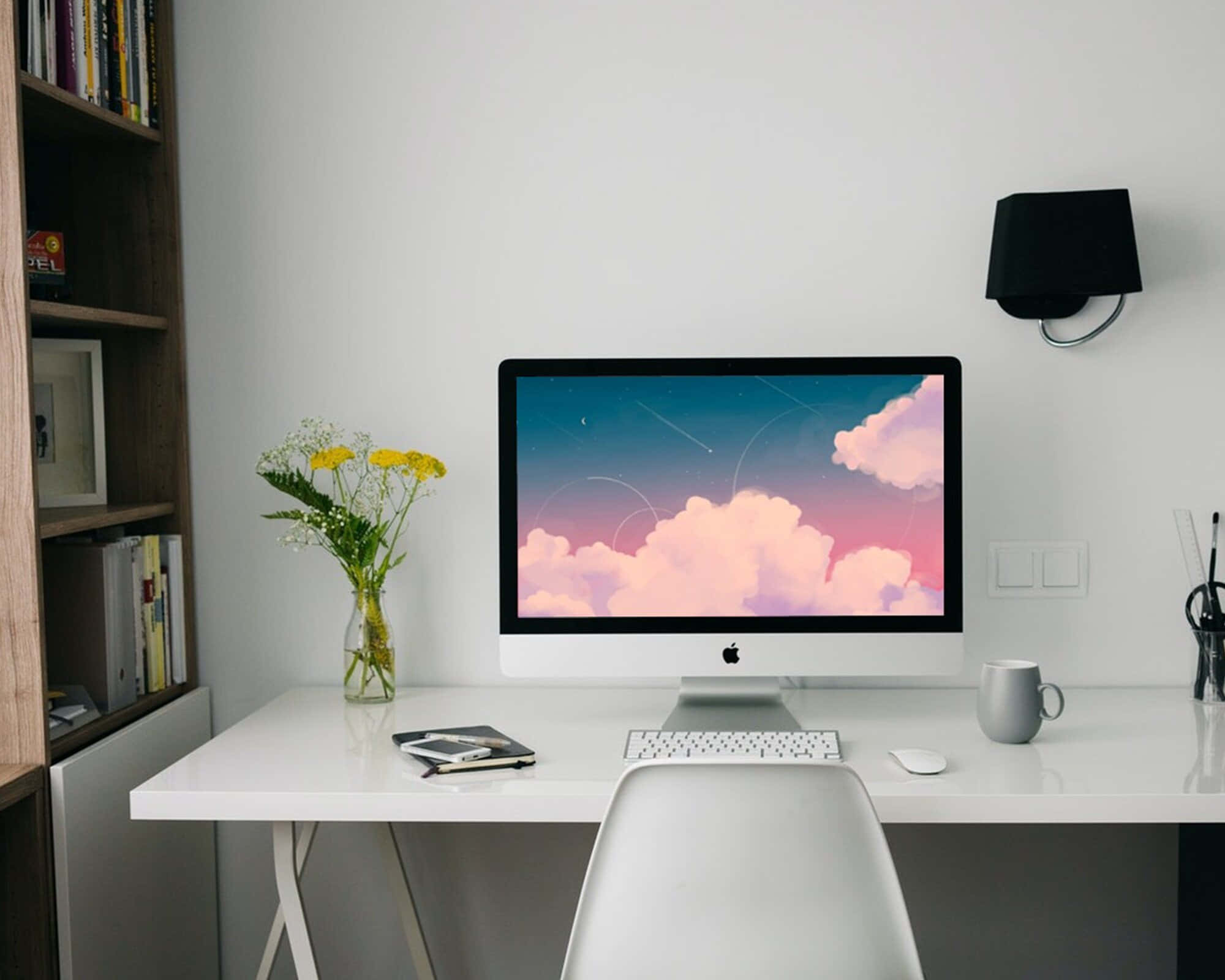 un escritorio blanco con una computadora y un florero Fondos de pantalla