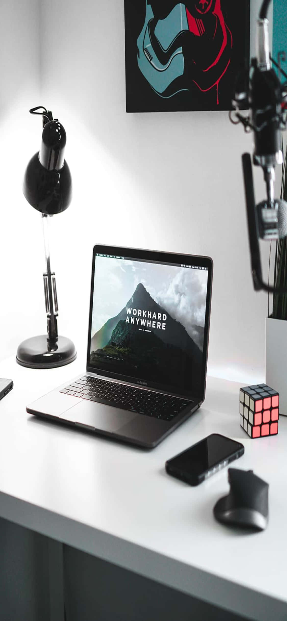 Un escritorio con laptop, teléfono y lámpara Fondos de pantalla