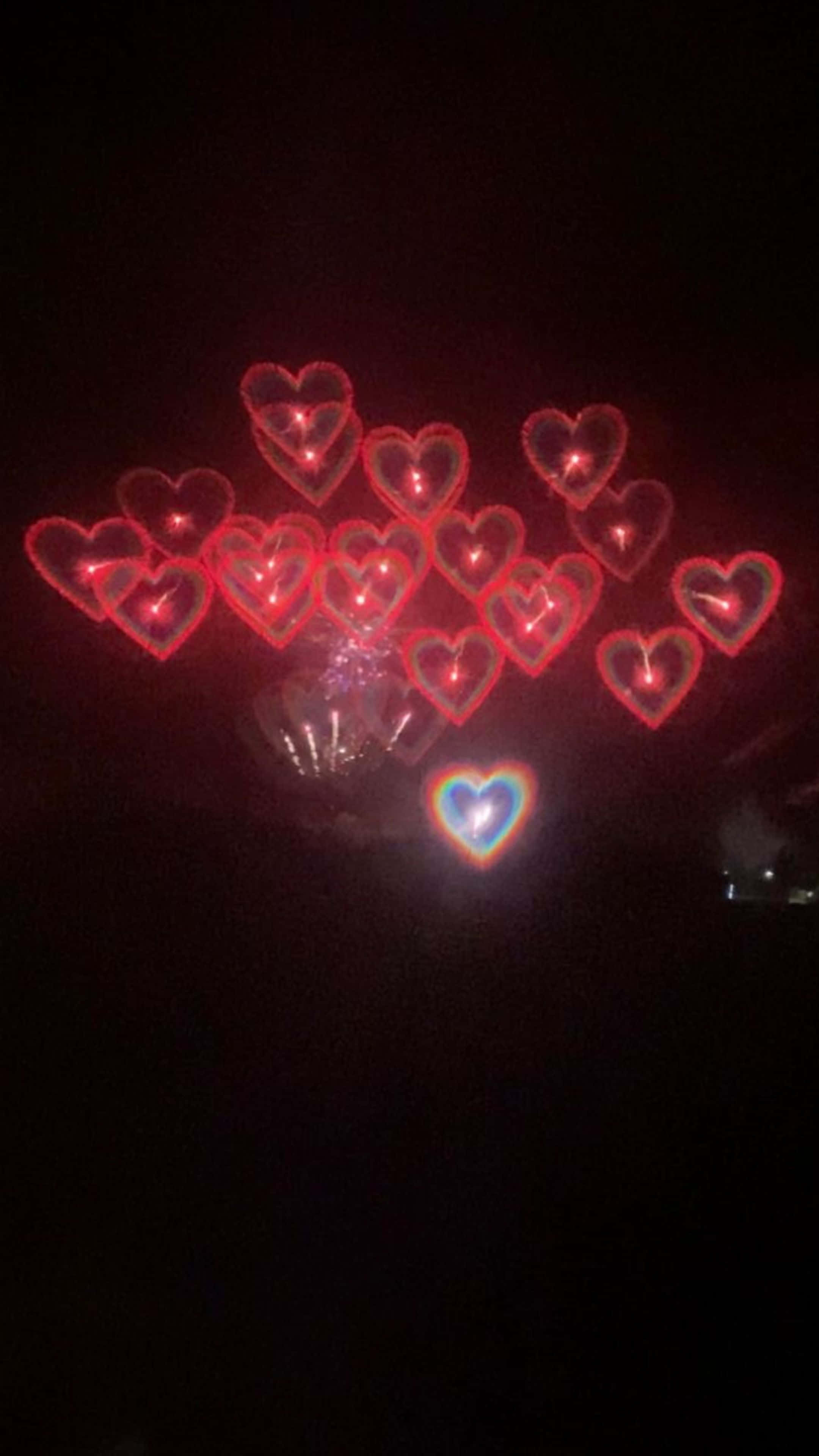 un fuego artificial en forma de corazón en la oscuridad Fondos de pantalla