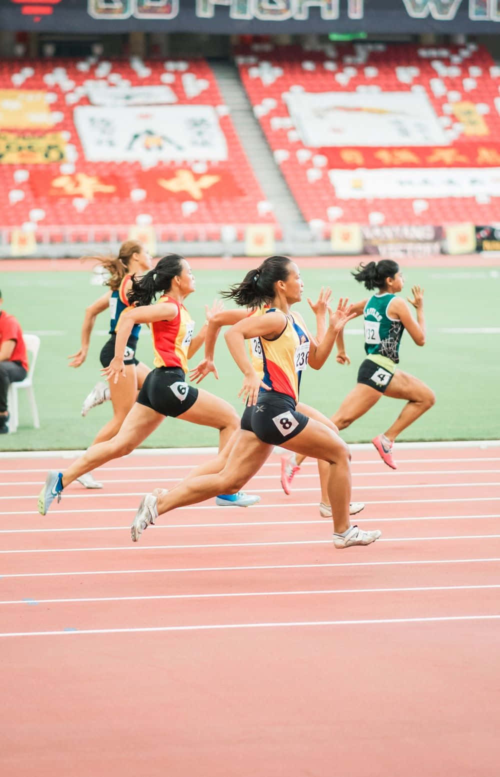 un grupo de mujeres corriendo en una pista en un estadio Fondos de pantalla