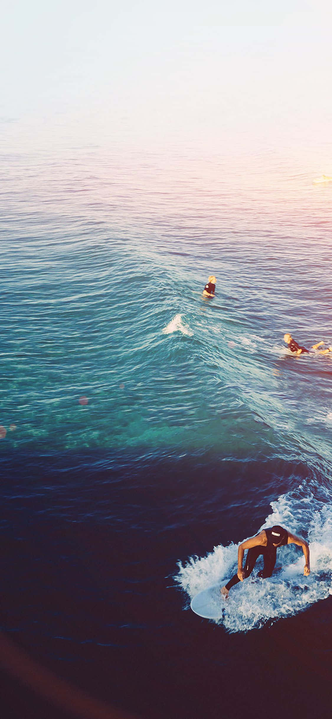 un grupo de personas surfeando una ola en el océano Fondos de pantalla