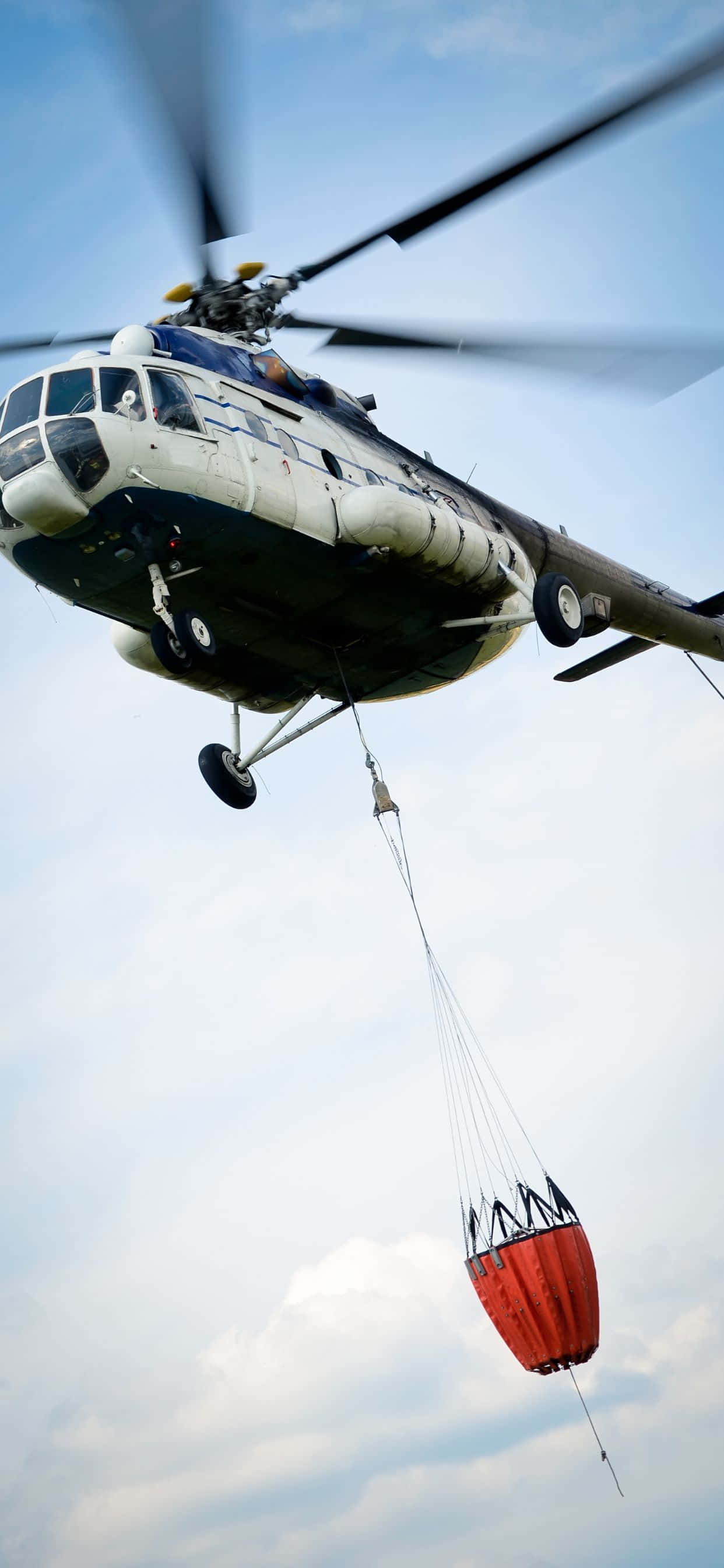 un helicóptero vuela con una bolsa roja atada Fondos de pantalla