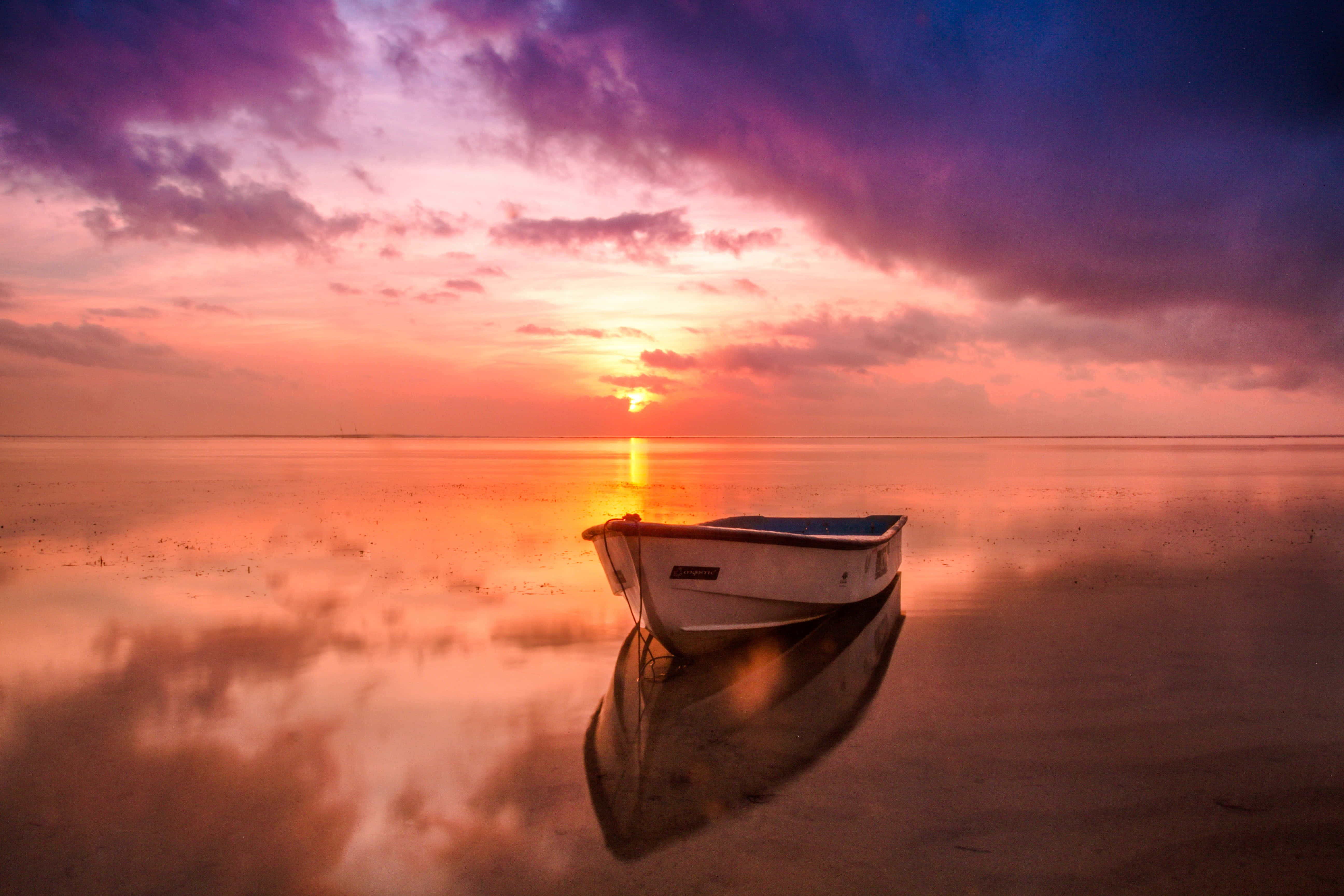Un hermoso atardecer se refleja en un lago tranquilo. Fondos de pantalla
