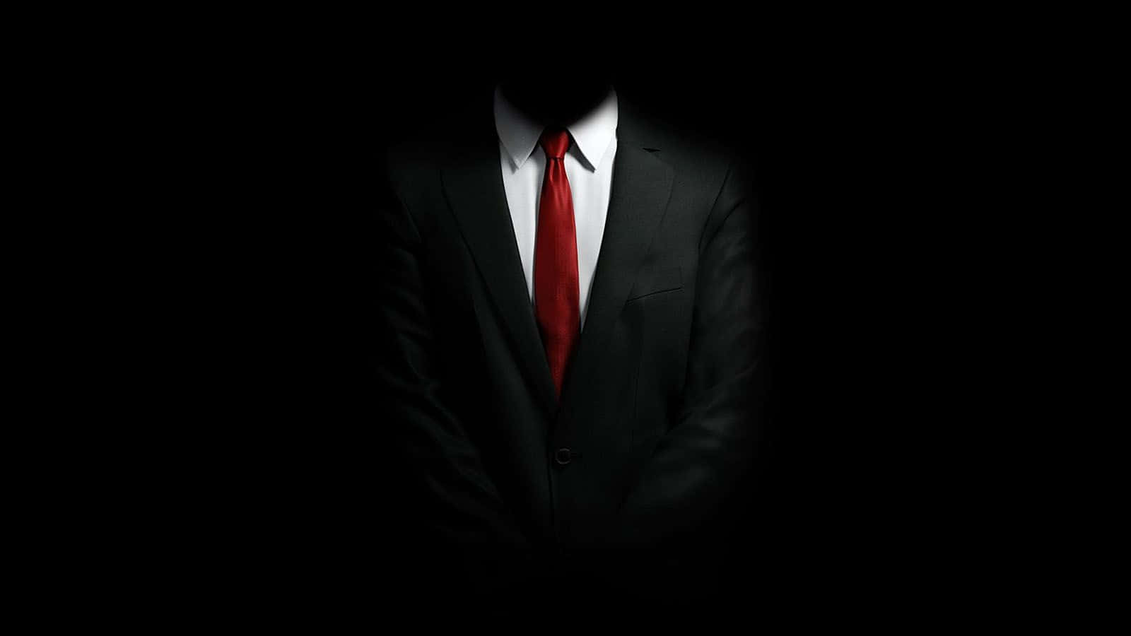 un hombre con traje y corbata está de pie en la oscuridad Fondos de pantalla