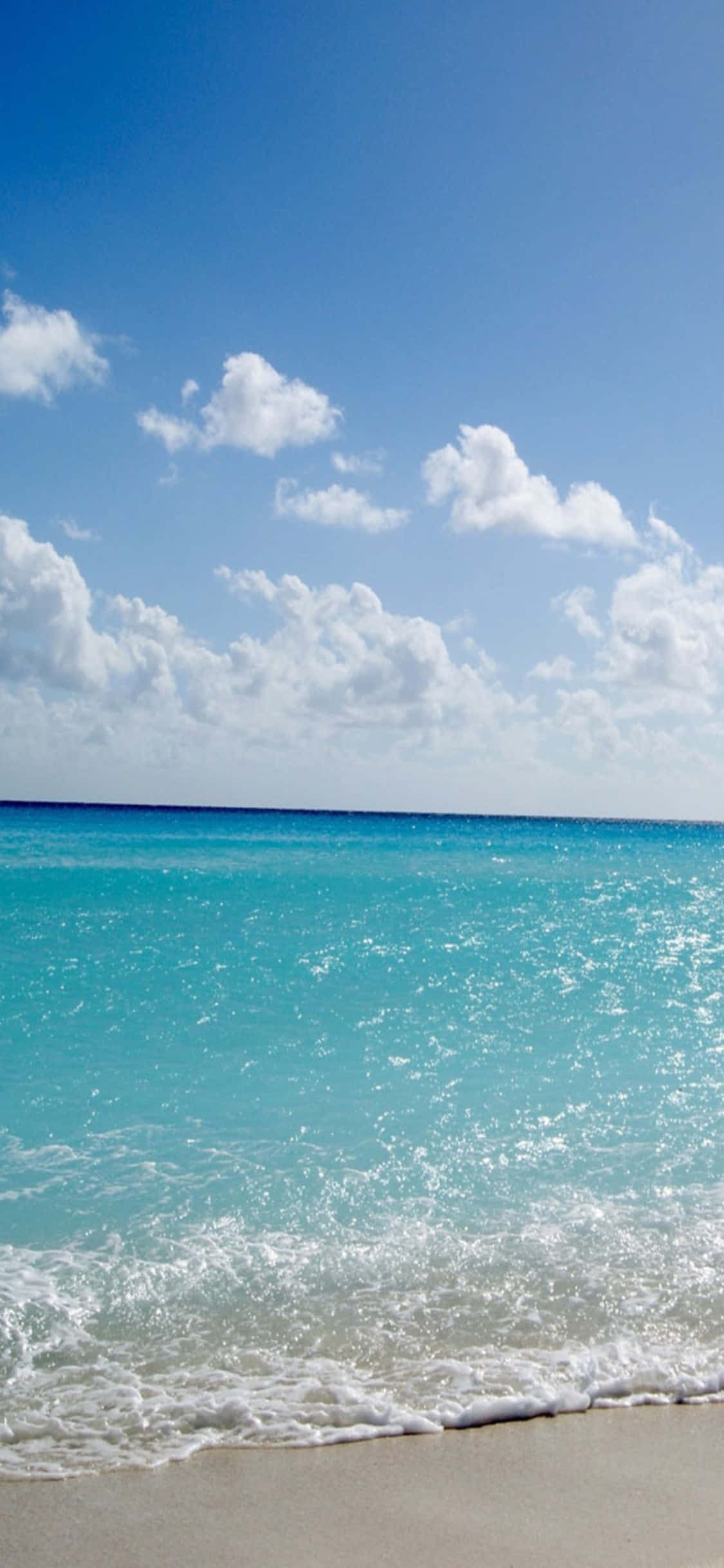 Un iPhone X mostrando un impresionante fondo de playa. Fondos de pantalla