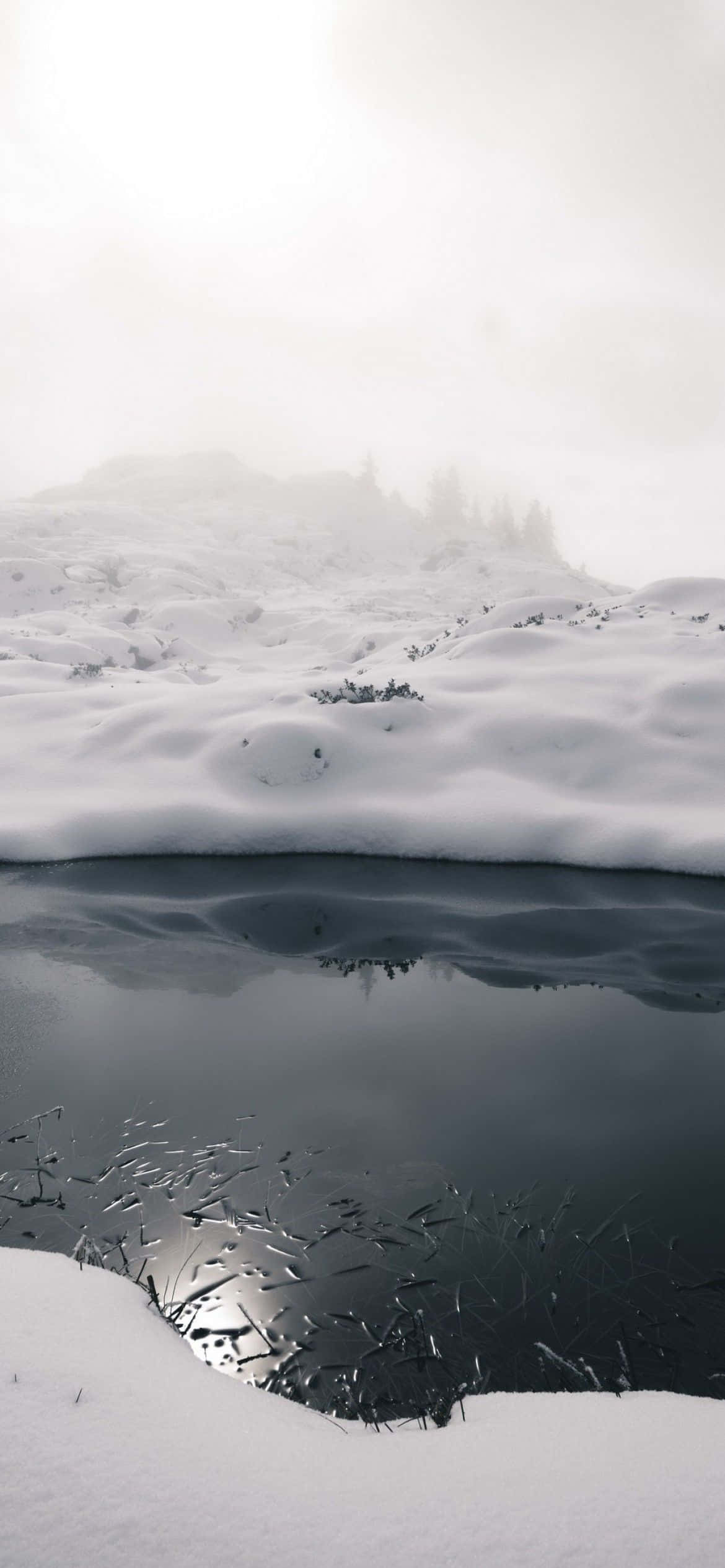 un lago cubierto de nieve con reflejo Fondos de pantalla