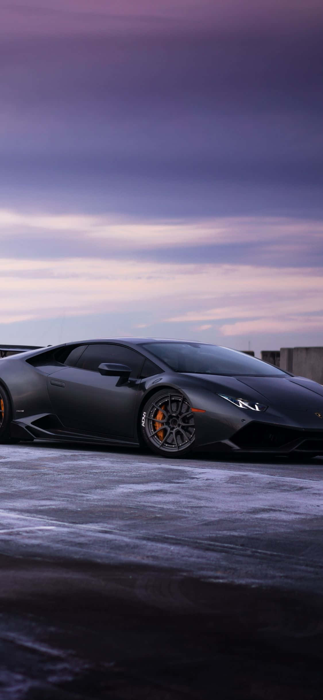 Un Lamborghini negro estacionado en una carretera nevada Fondos de pantalla