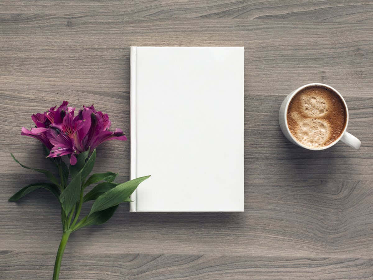 Un libro blanco y una taza de café sobre una mesa de madera Fondos de pantalla