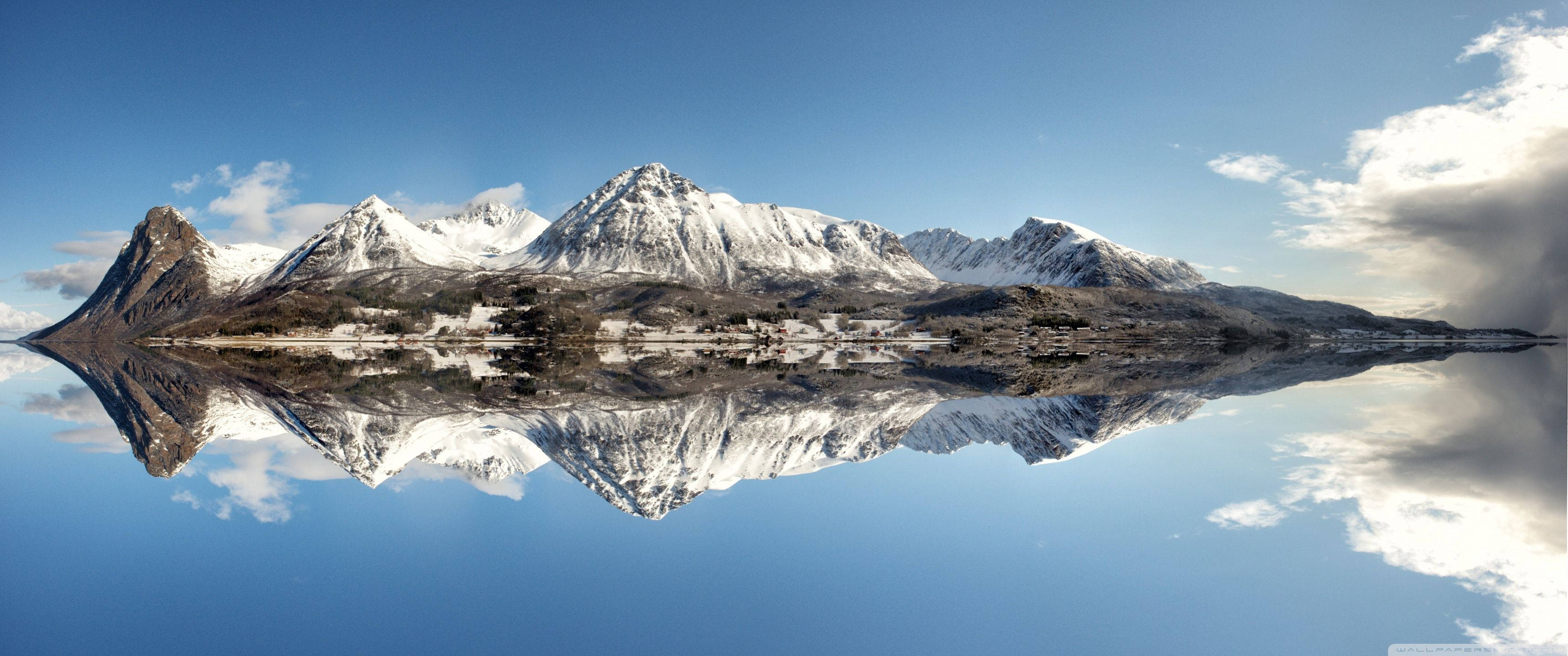 Un magnífico reflejo de montañas nevadas. Fondos de pantalla