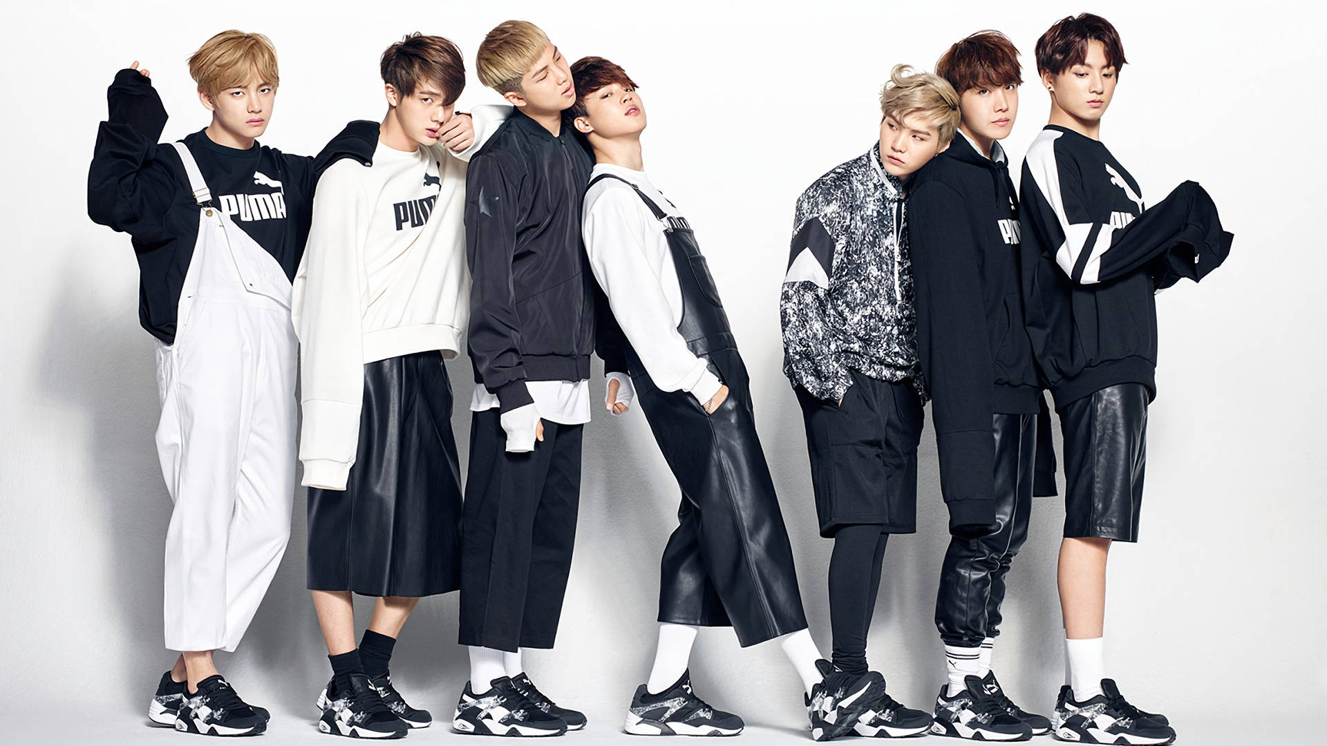 Miembros de la banda BTS V, Jungkook, Jimin, Suga, Jin, RM y J-Hope con atuendos en blanco y negro.