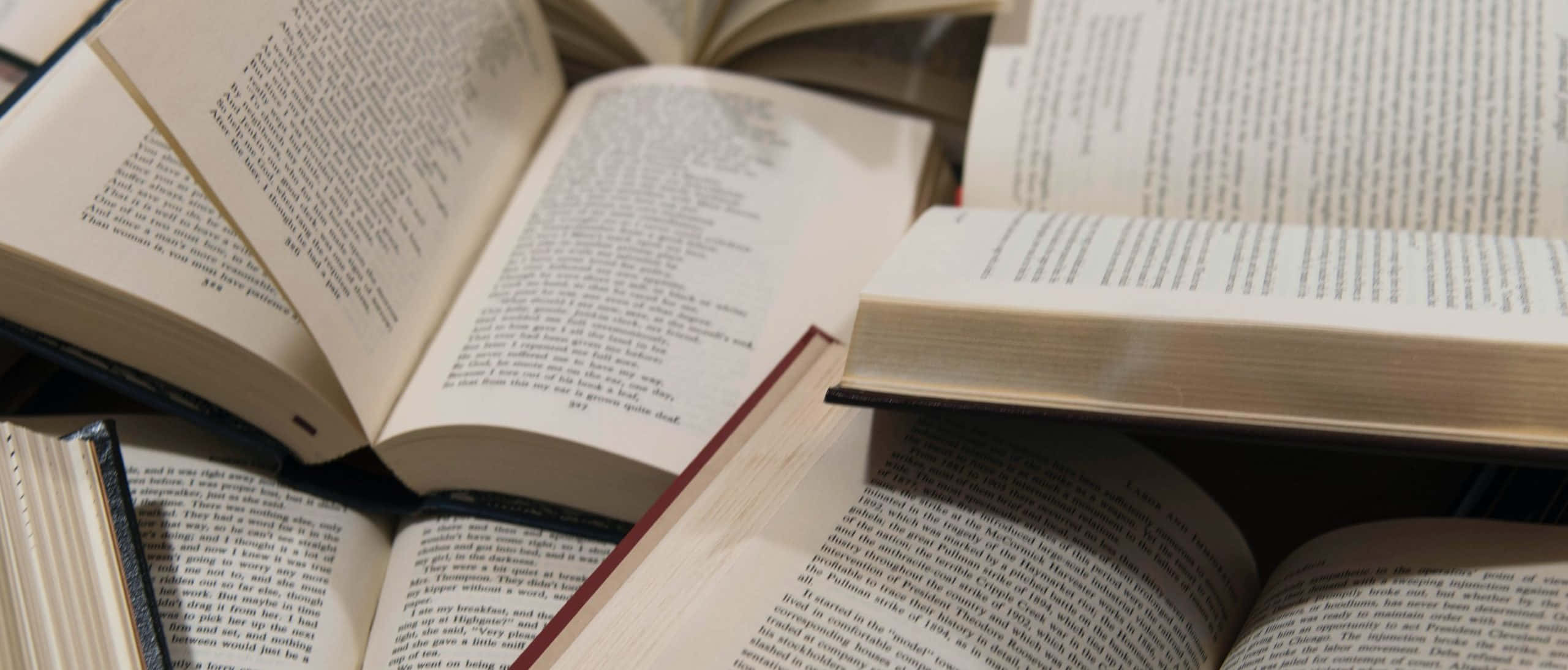 un montón de libros sobre una mesa Fondos de pantalla