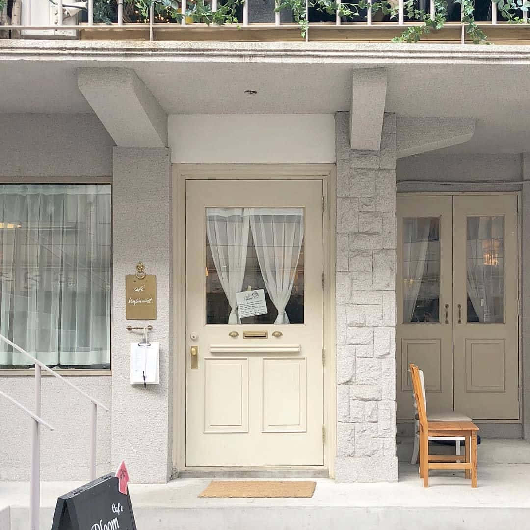 un pequeño edificio con una puerta y una banca Fondos de pantalla
