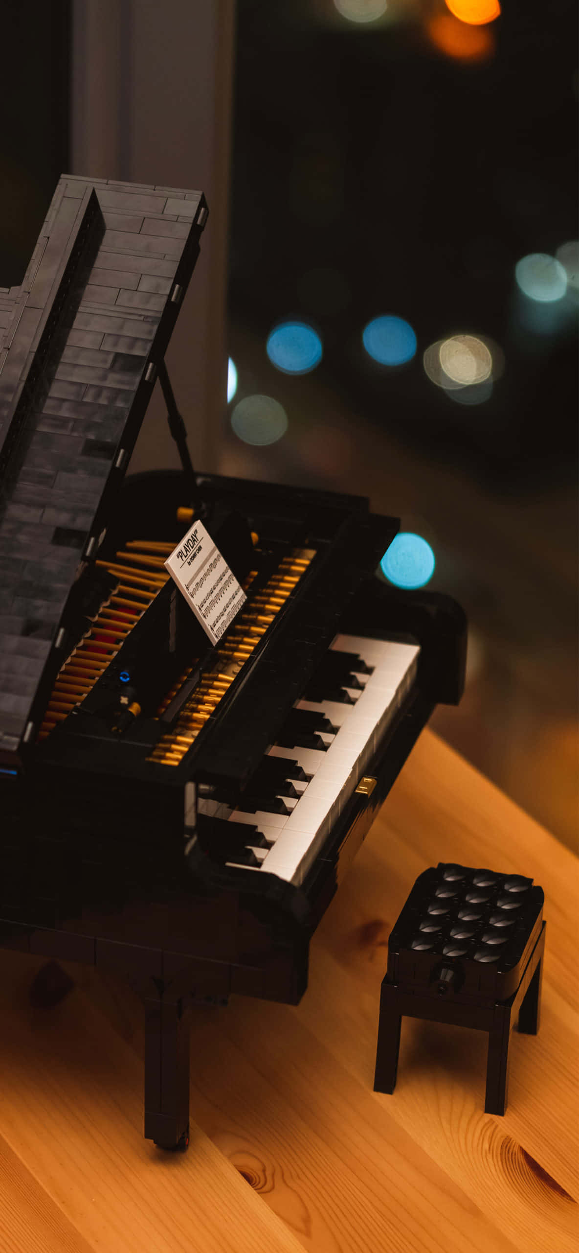 un piano de lego sobre una mesa con un taburete Fondos de pantalla