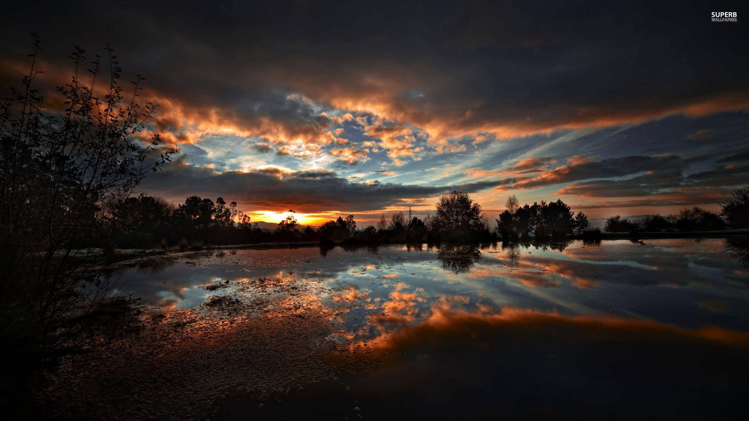 Un reflejo pacífico y sereno de un atardecer oscuro Fondos de pantalla