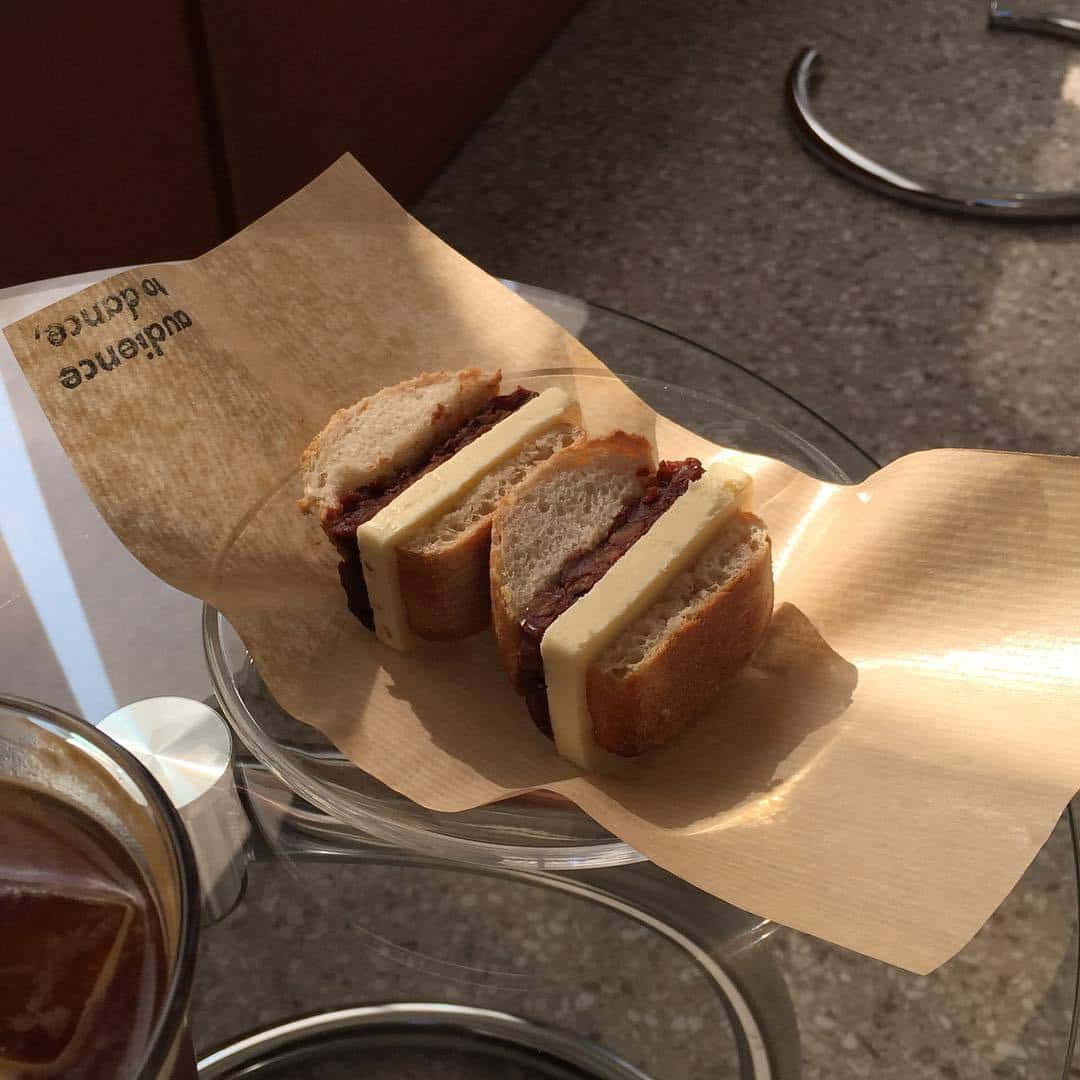 un sándwich en un plato con una taza de café Fondos de pantalla