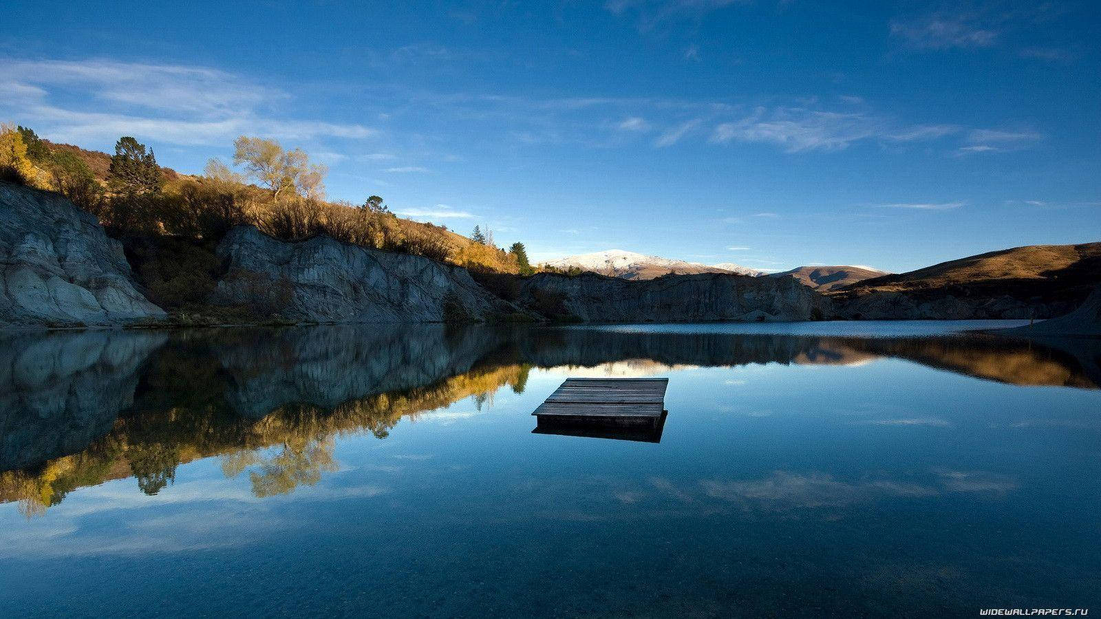 Un sendero rústico de tablones de madera rodeado de naturaleza exuberante Fondos de pantalla