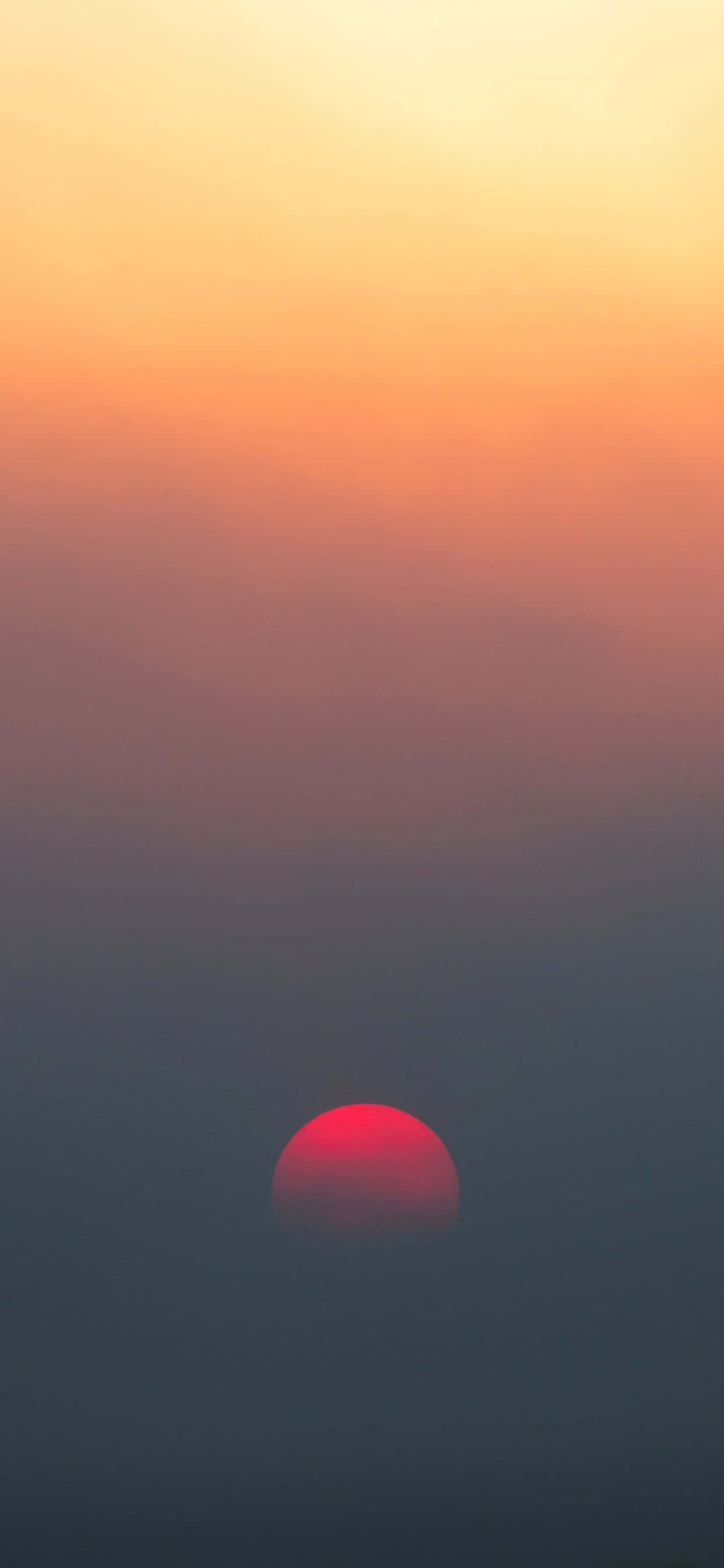 un sol rojo elevándose sobre un cielo lleno de niebla Fondos de pantalla