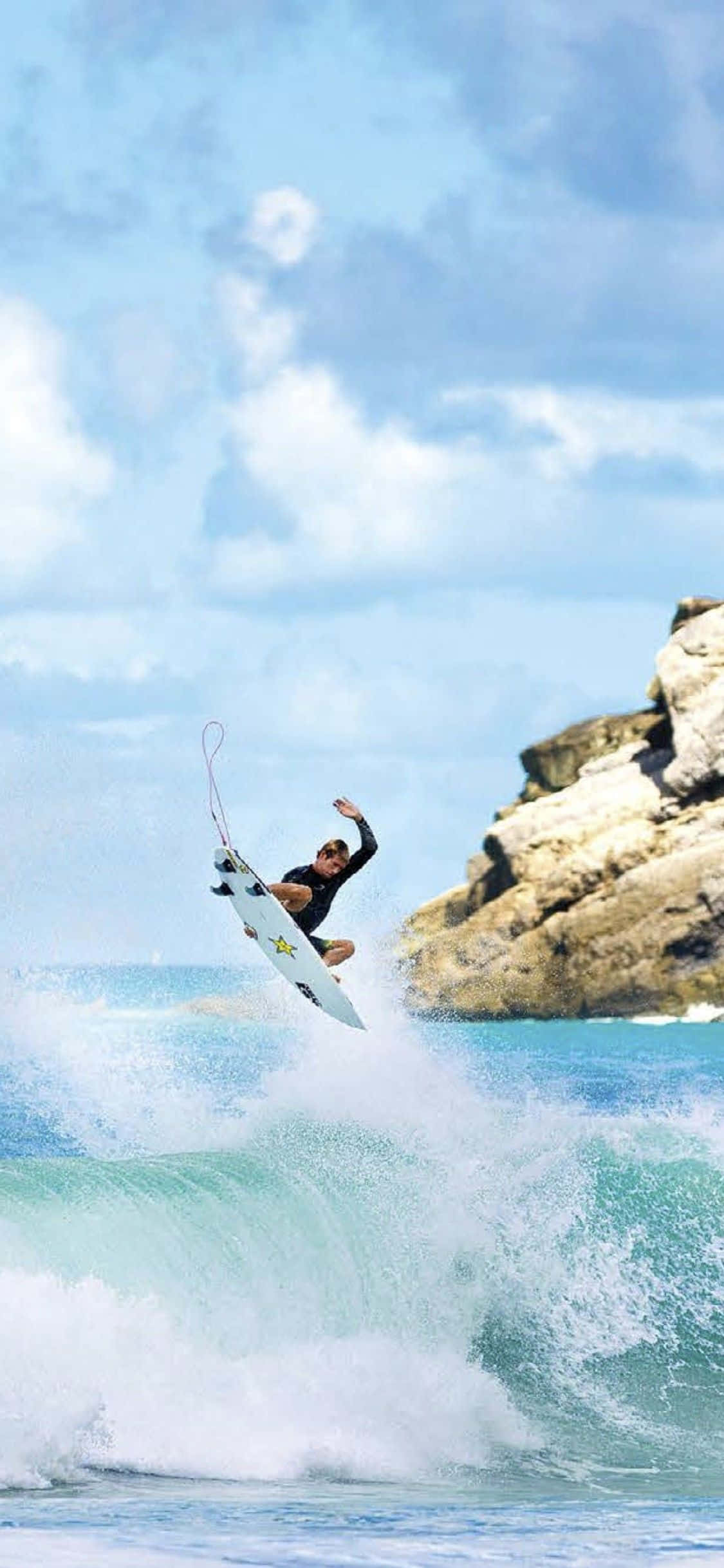 un surfista cabalgando una ola Fondos de pantalla
