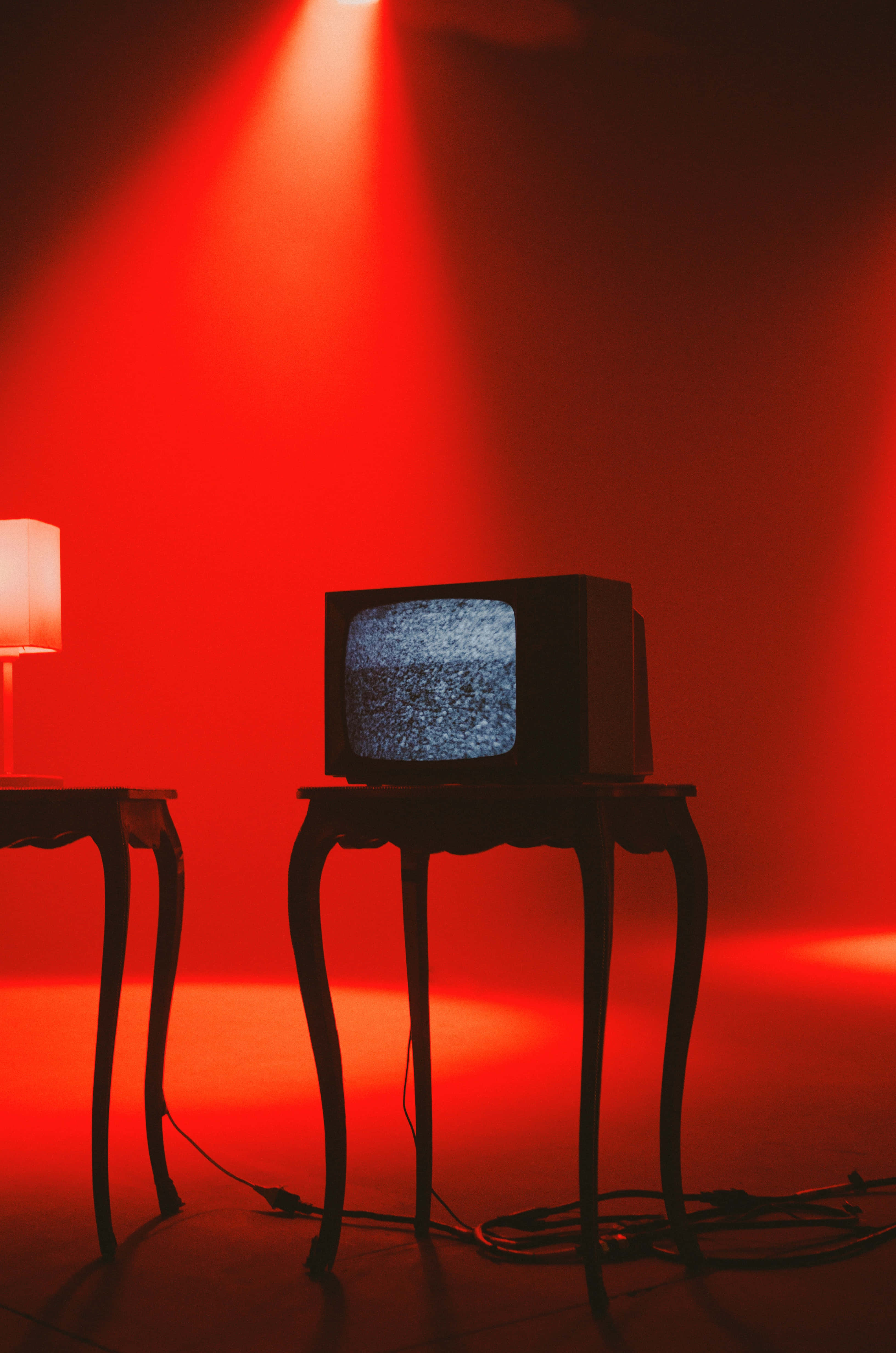 un televisor y una lámpara sobre una mesa Fondos de pantalla