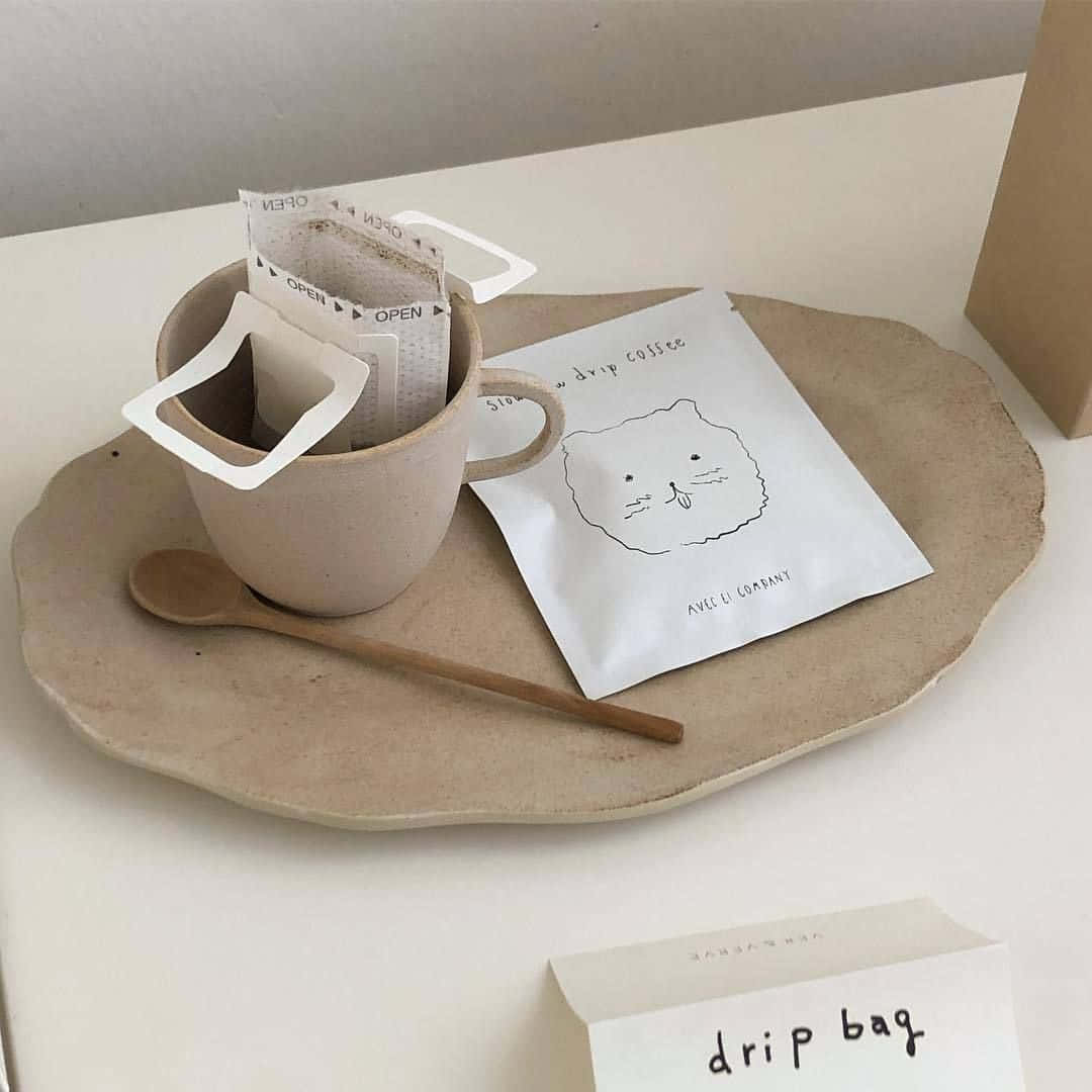 Una bandeja con una taza, una cuchara y una bolsa Fondos de pantalla