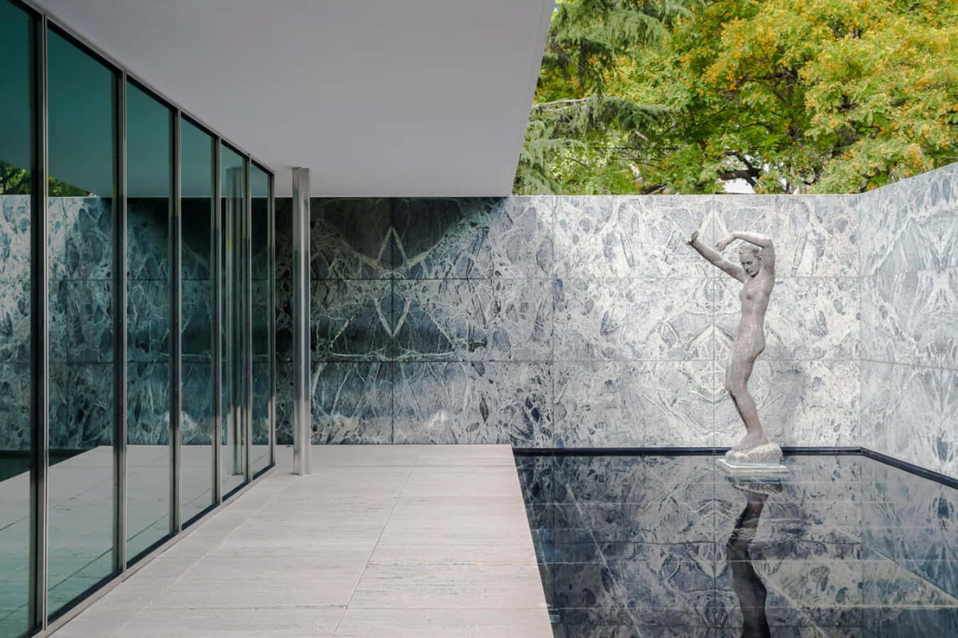 Una casa con un gran muro de vidrio y una estatua Fondos de pantalla
