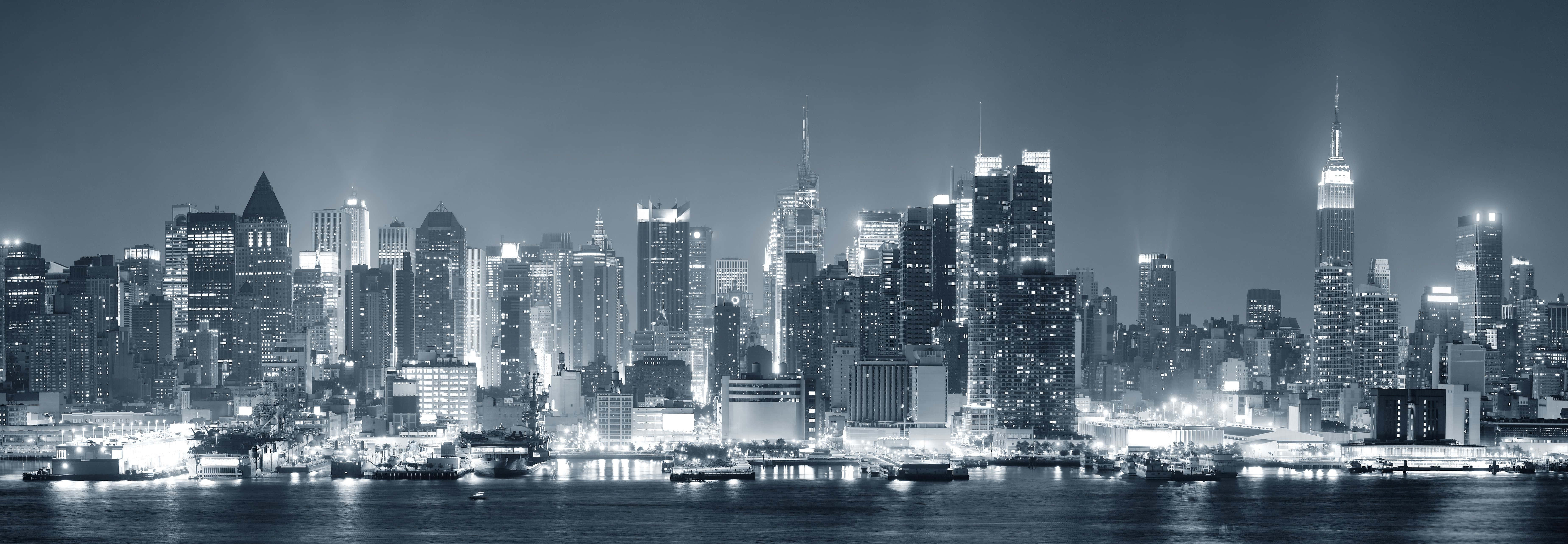 una foto en blanco y negro del horizonte de una ciudad por la noche Fondos de pantalla
