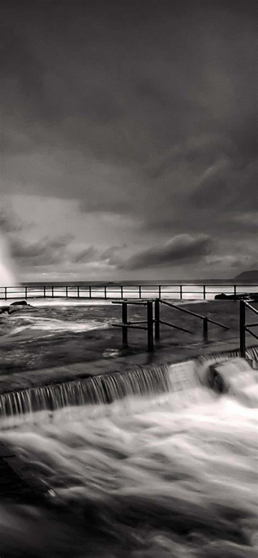 una foto en blanco y negro de un muelle con olas Fondos de pantalla
