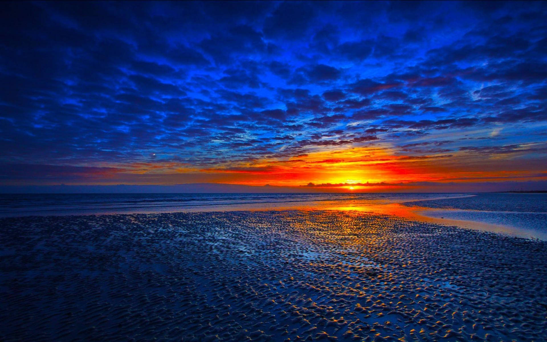 Una hermosa puesta de sol vista desde una playa tropical Fondos de pantalla
