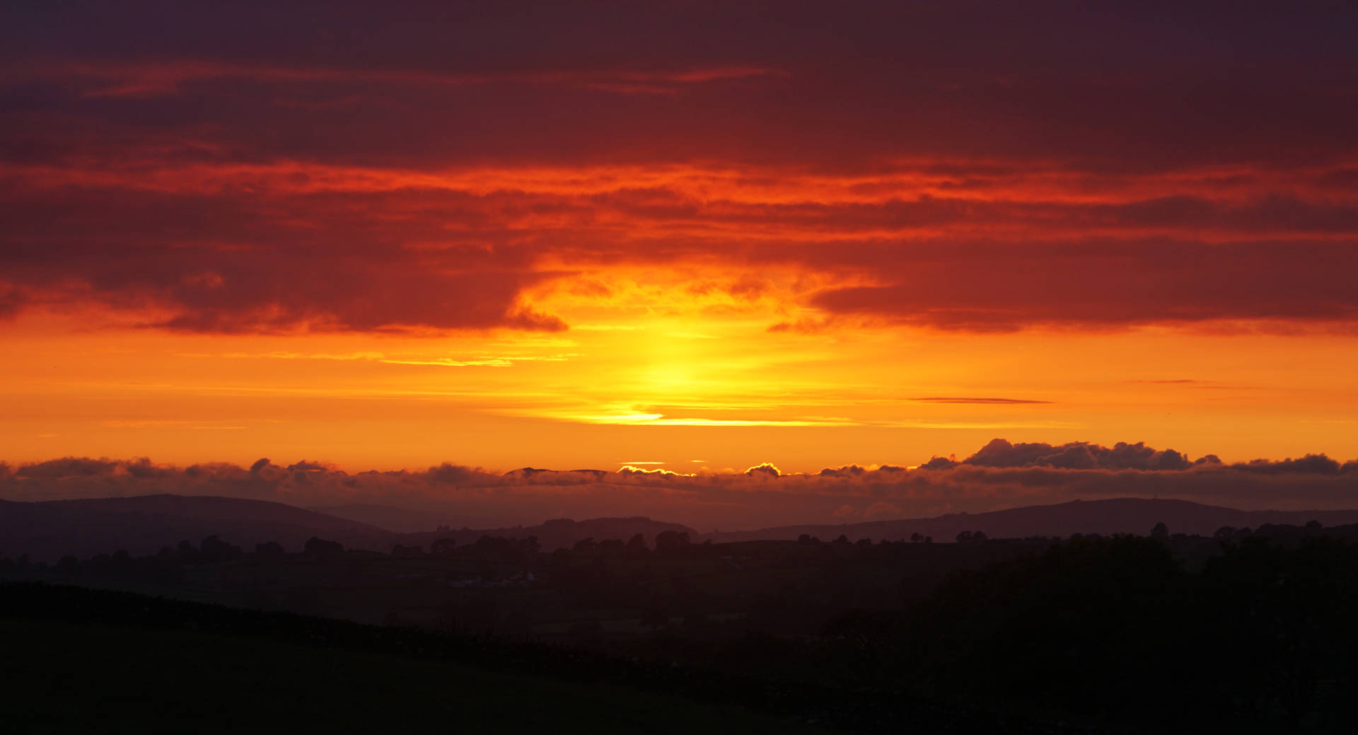 Atardecer en un cielo naranja que muestra el horizonte antes de que oscurezca.