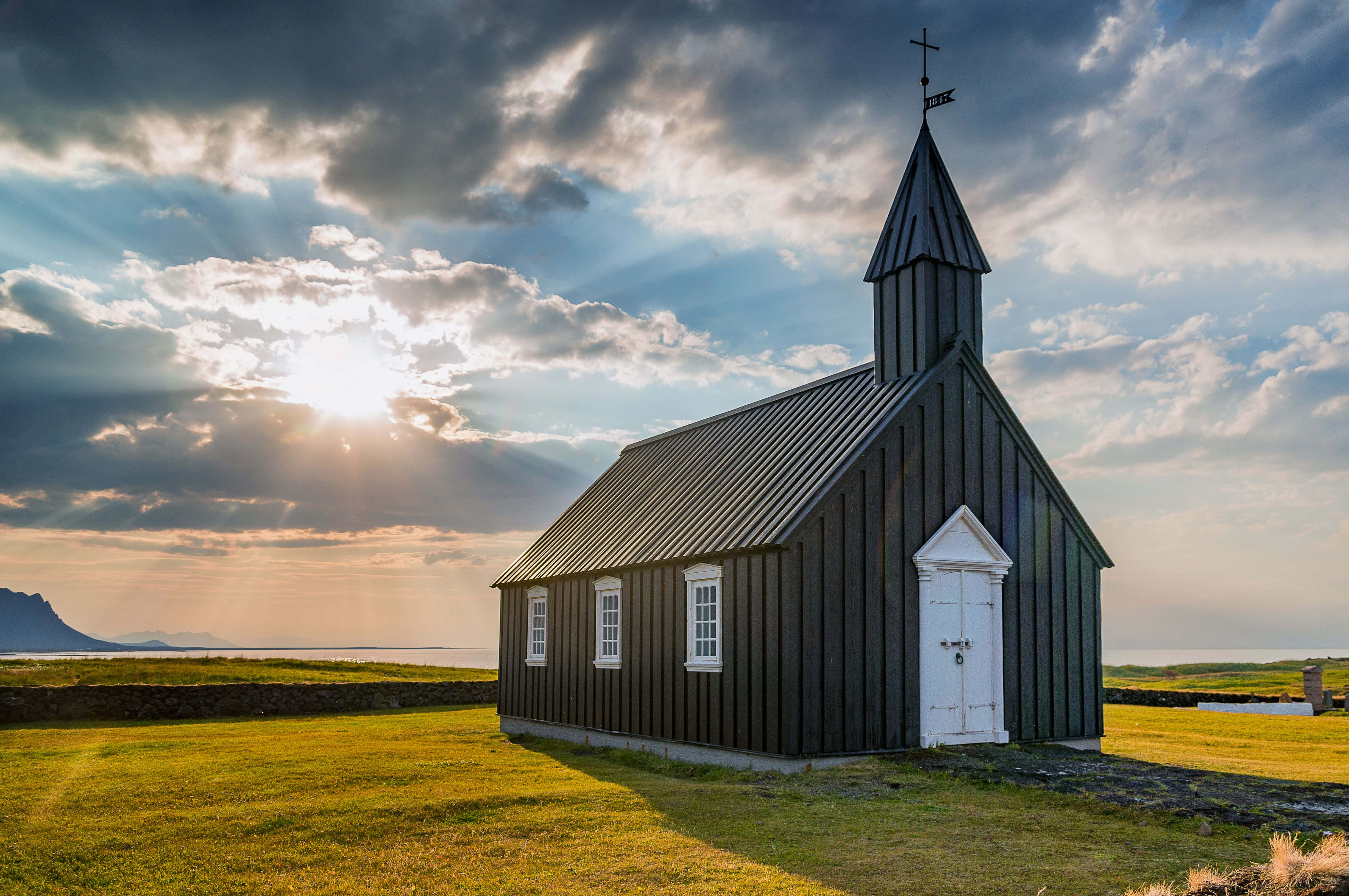 una iglesia negra se encuentra en un campo de hierba Fondos de pantalla