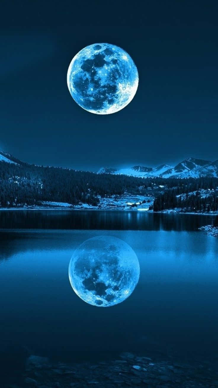una luna azul se refleja en un lago Fondos de pantalla
