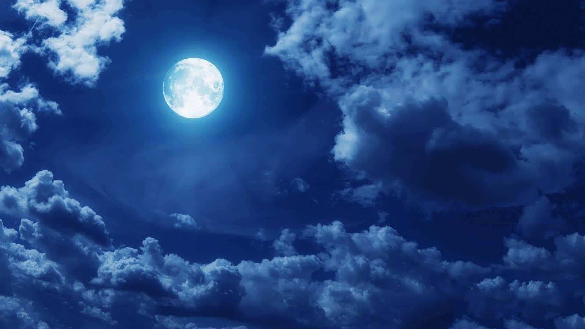 una luna llena se ve a través de las nubes en el cielo Fondos de pantalla