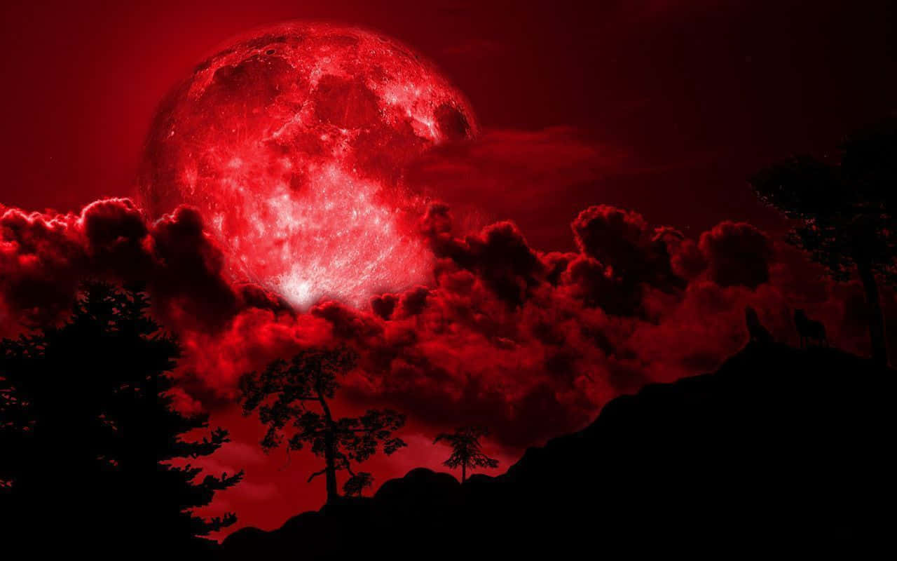 una luna roja con nubes y árboles al fondo Fondos de pantalla