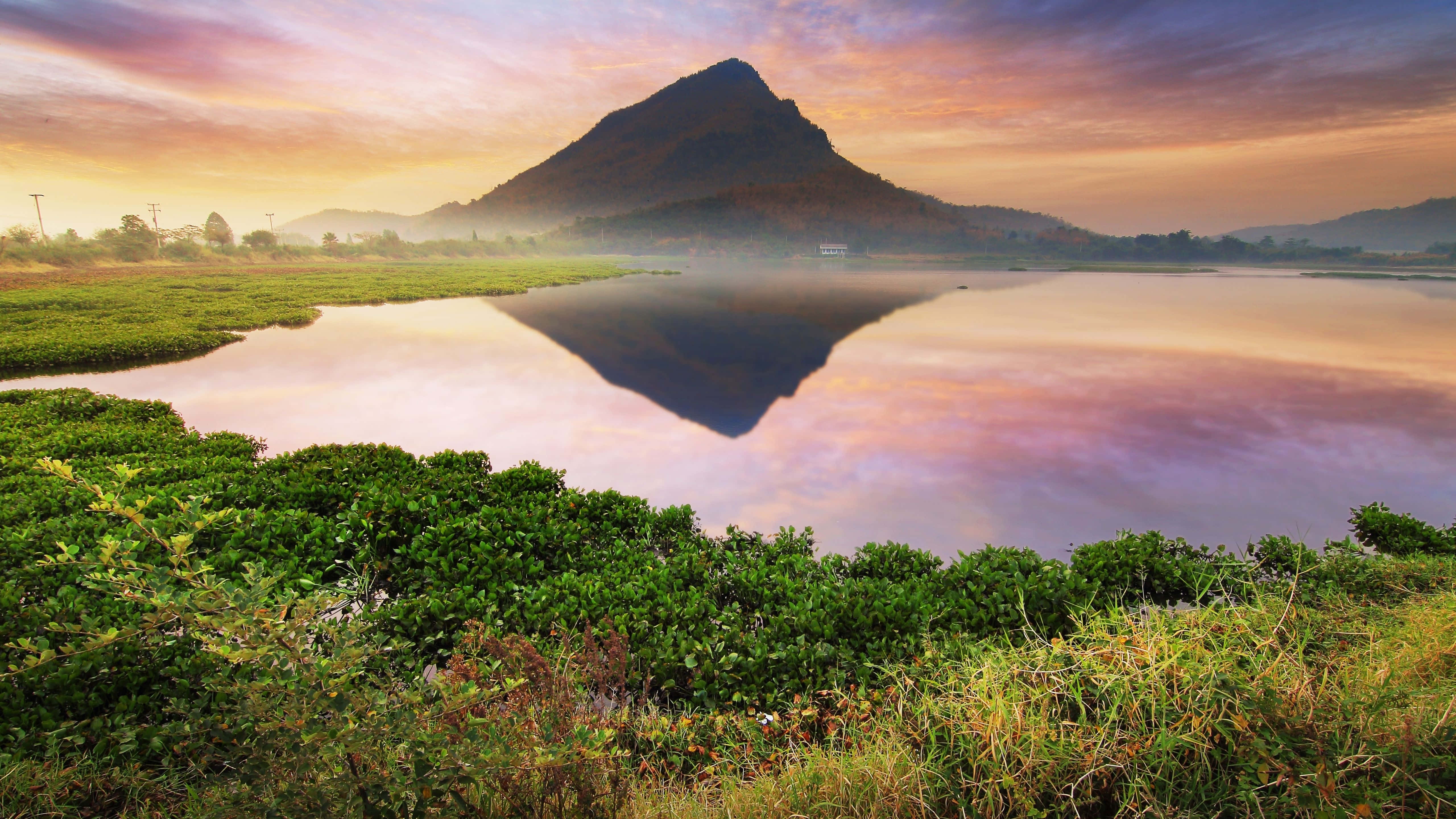 una montaña se refleja en el agua Fondos de pantalla