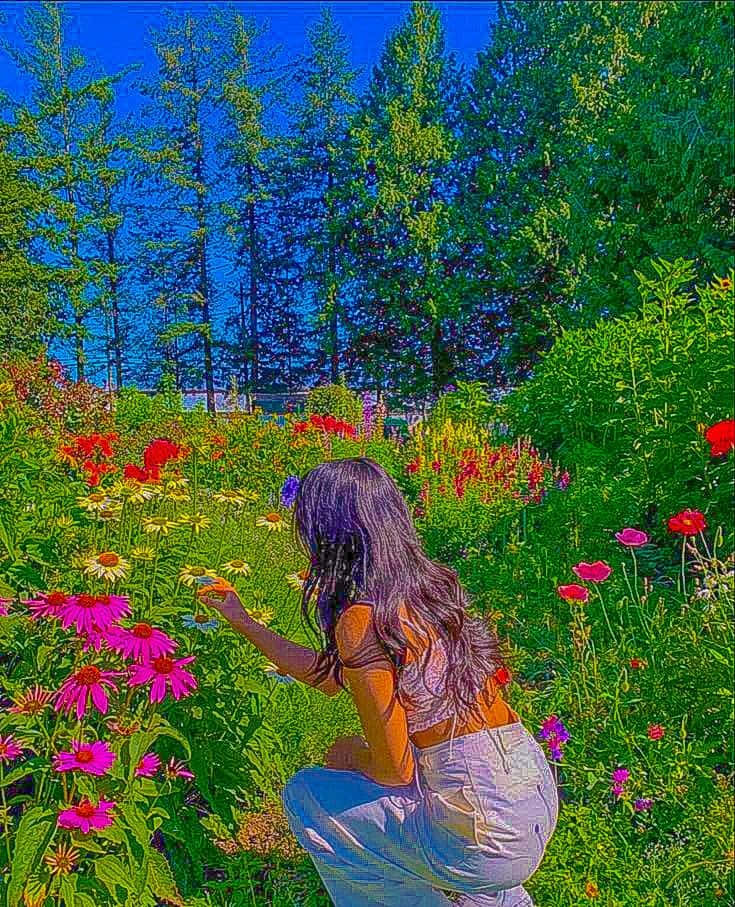 una mujer arrodillada en un jardín de flores Fondos de pantalla