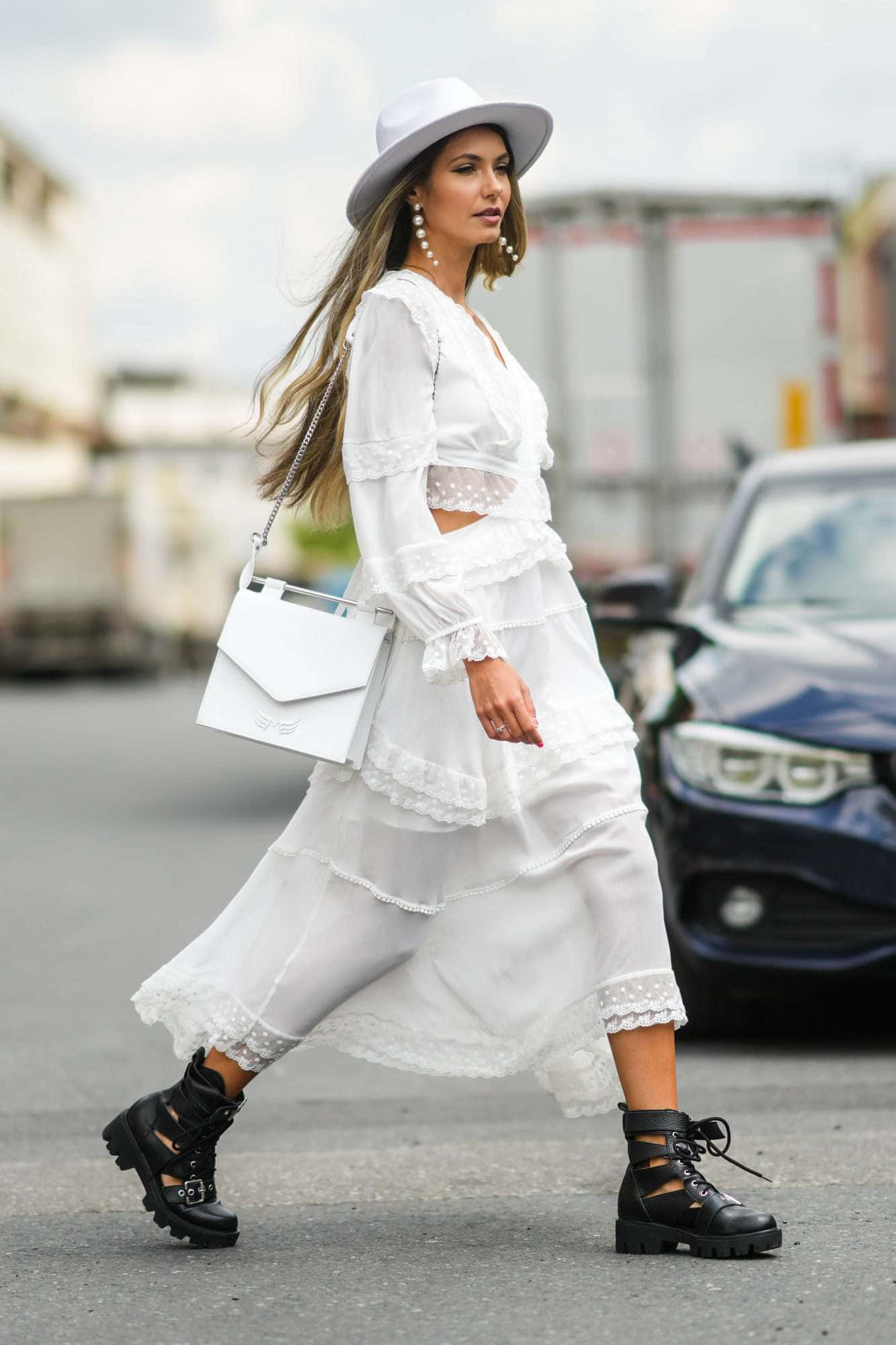 una mujer con vestido blanco y sombrero caminando por la calle Fondos de pantalla