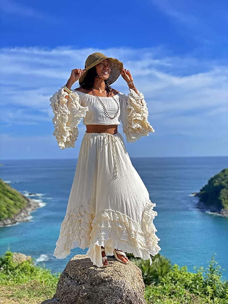 una mujer con vestido blanco de pie sobre una roca Fondos de pantalla