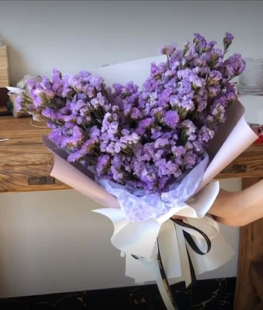 Una mujer sostiene un ramo de flores moradas Fondos de pantalla
