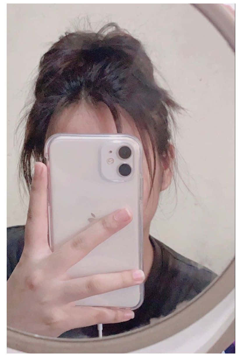 una mujer tomándose una selfie en el espejo Fondos de pantalla