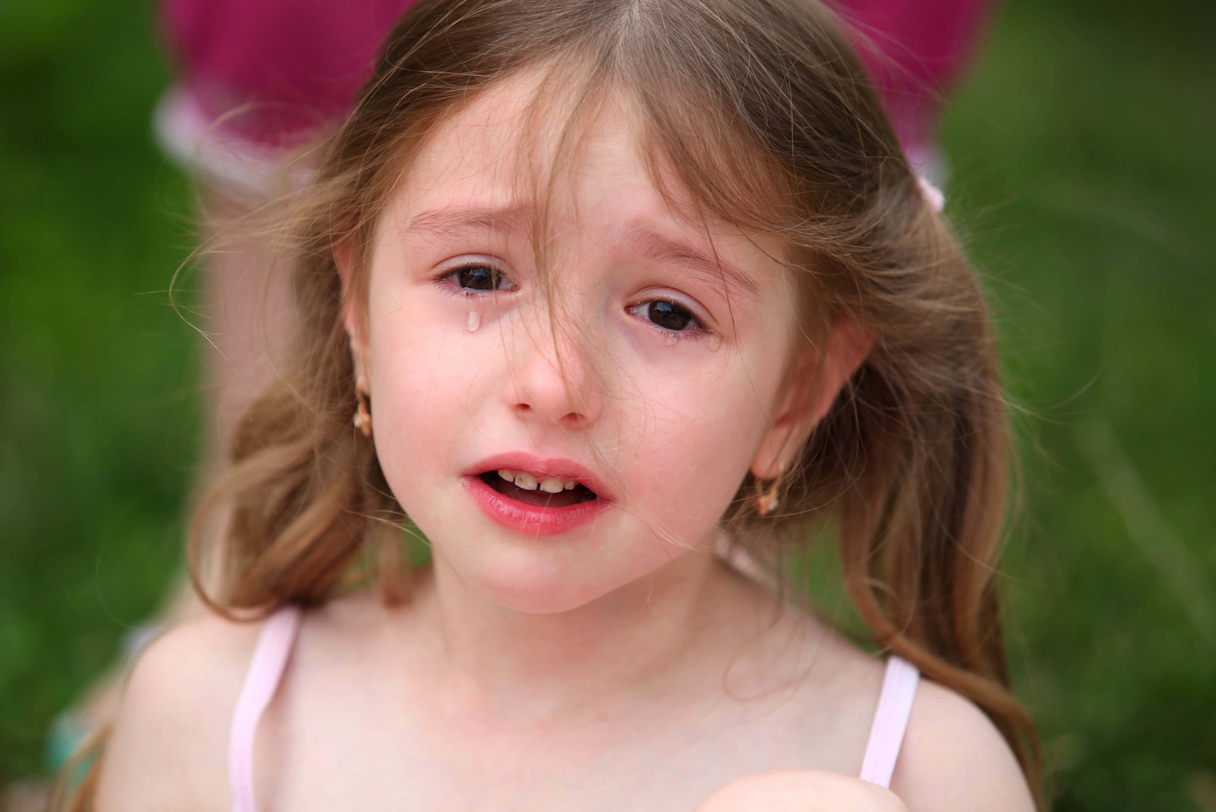 Una niña pequeña llora en el pasto Fondos de pantalla