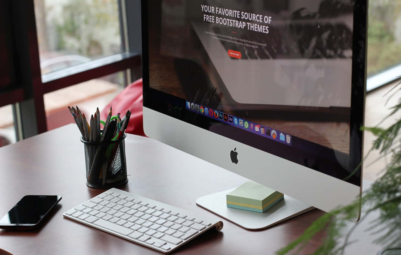 Una pantalla de computadora sobre un escritorio con una planta Fondos de pantalla