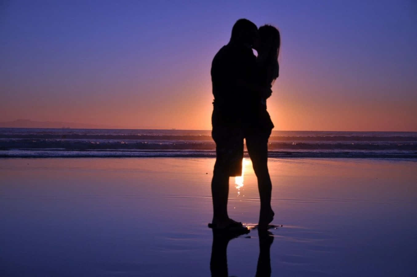 una pareja besándose en la playa al atardecer Fondos de pantalla