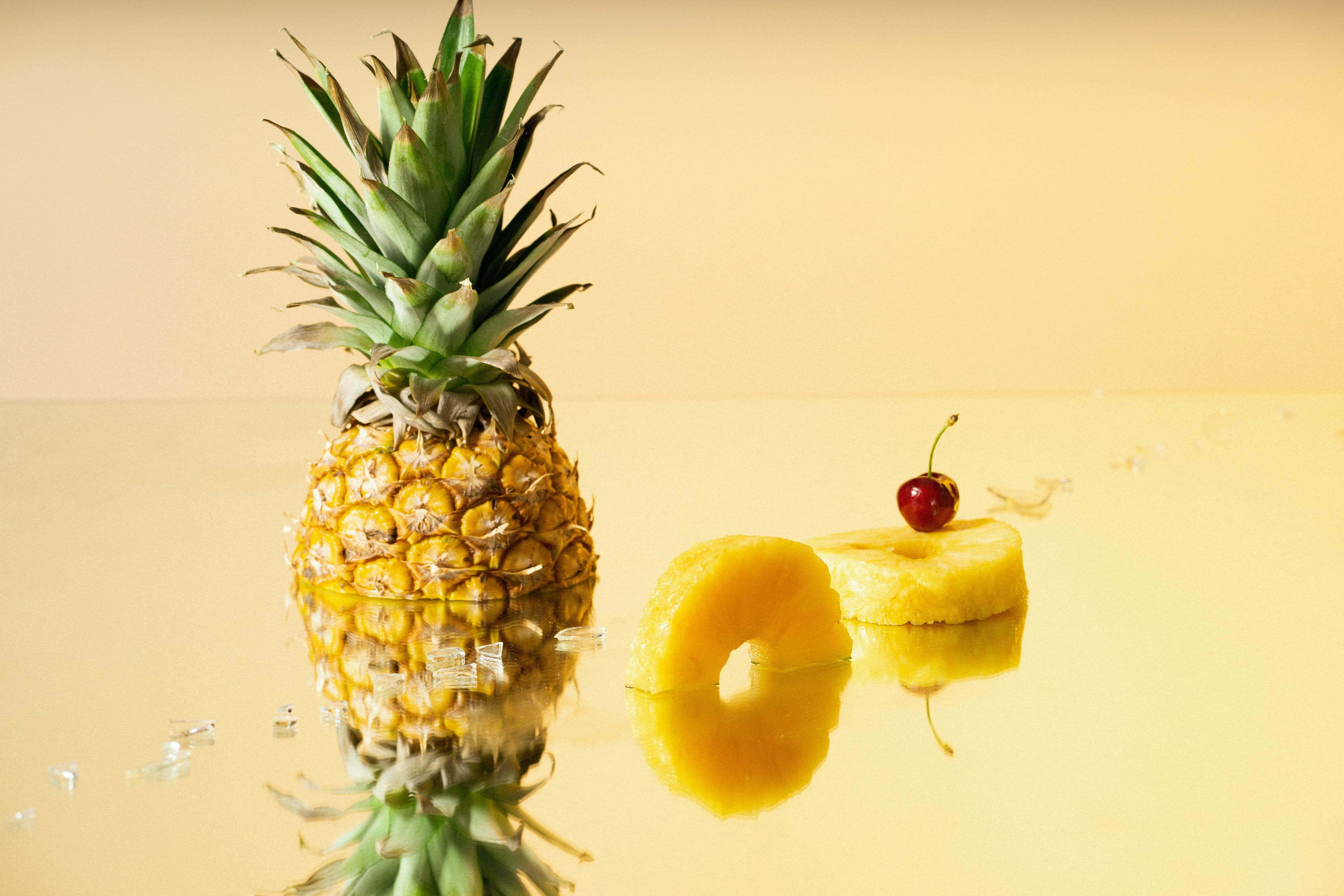 Una piña fresca y jugosa destaca al frente de una puesta de sol pintoresca Fondos de pantalla