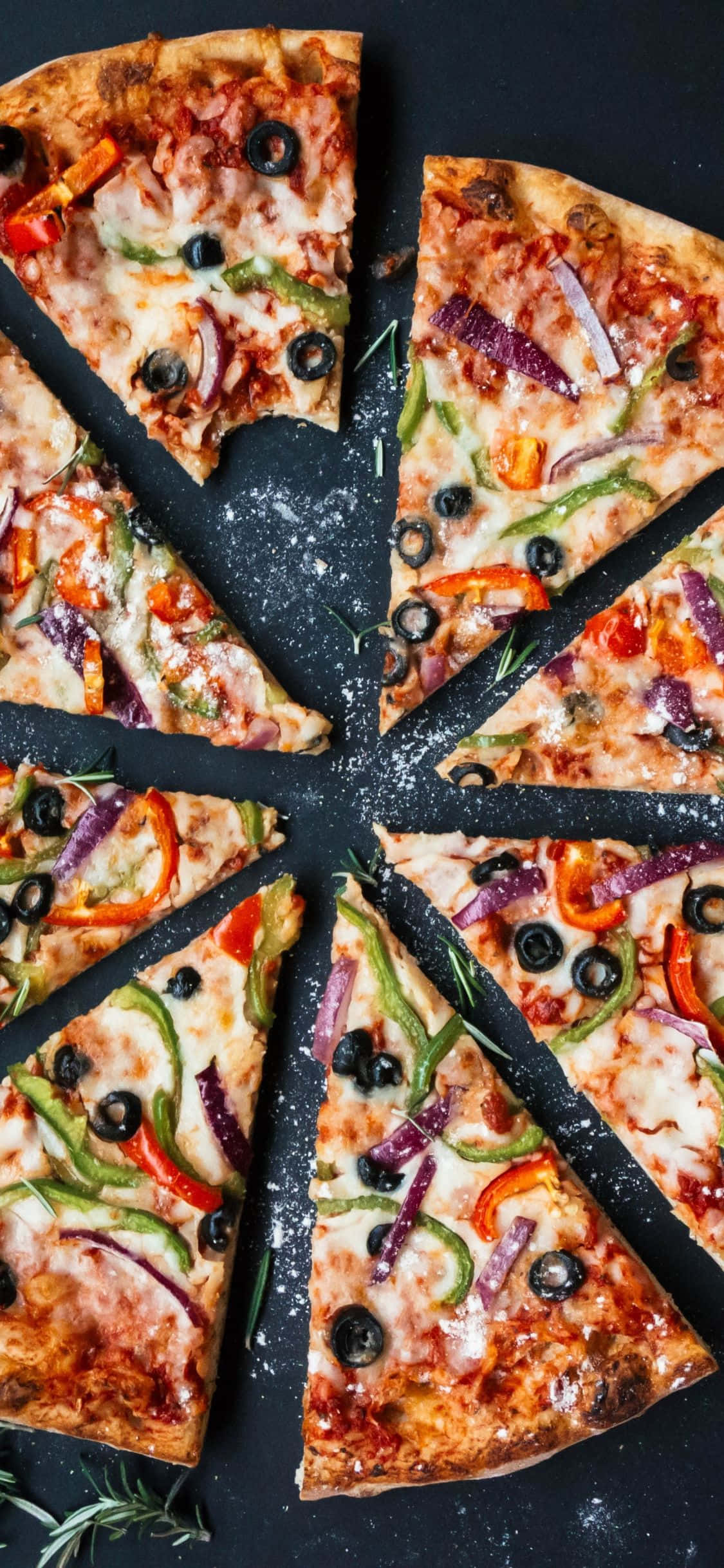 una pizza con verduras y aceitunas cortada en rebanadas Fondos de pantalla