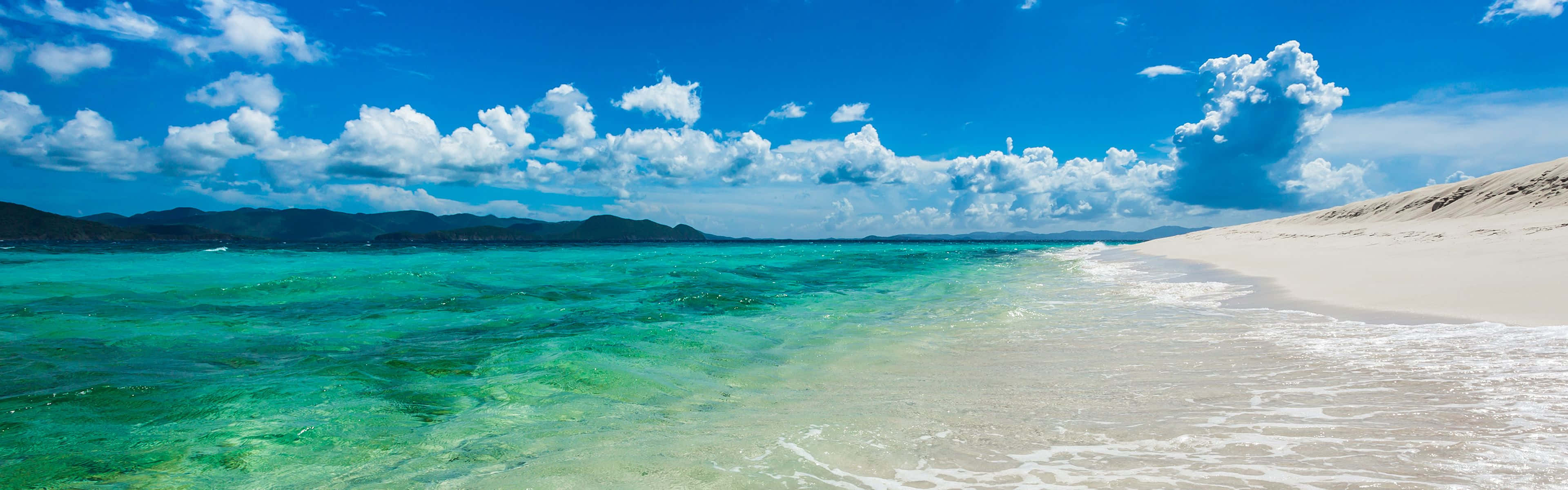 una playa con agua cristalina y arena blanca Fondos de pantalla