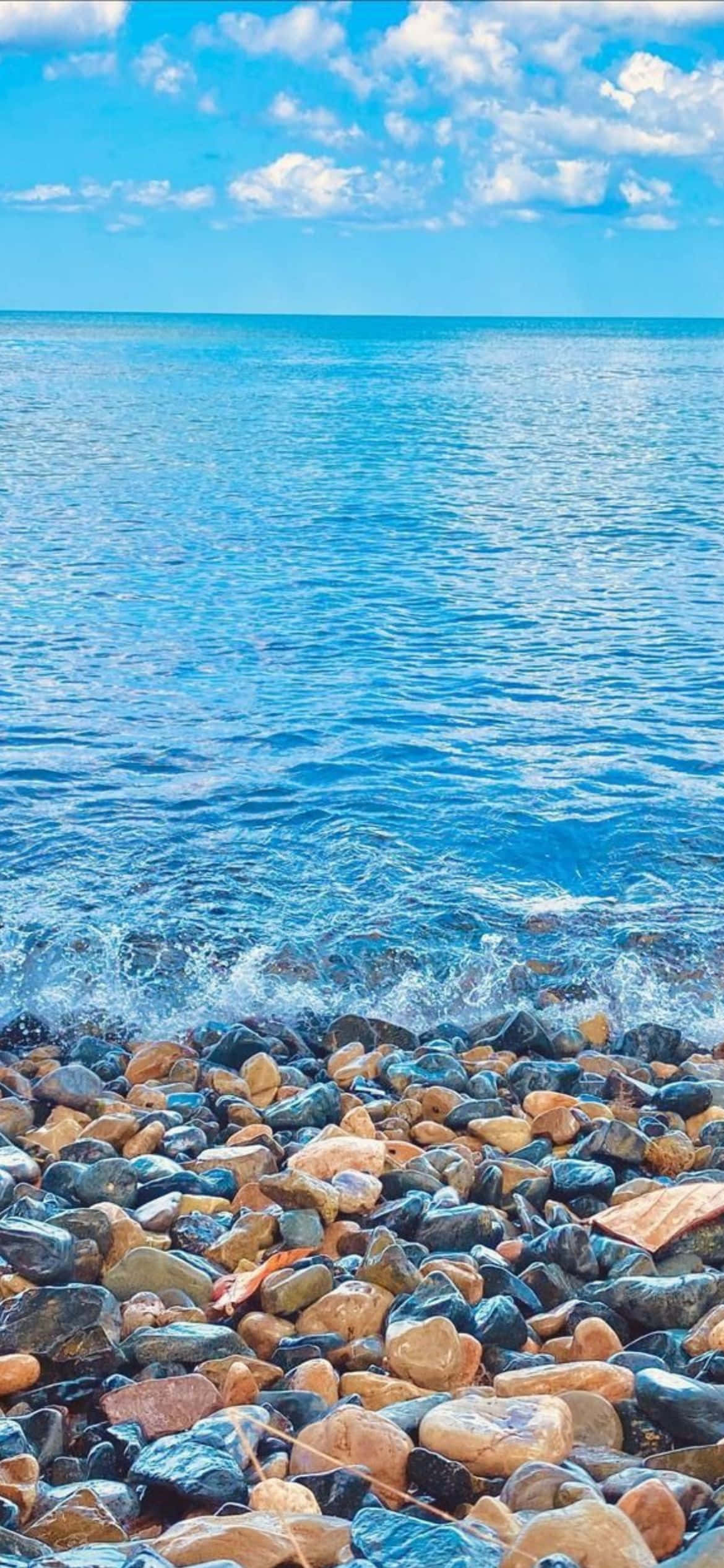 una playa con rocas y agua Fondos de pantalla